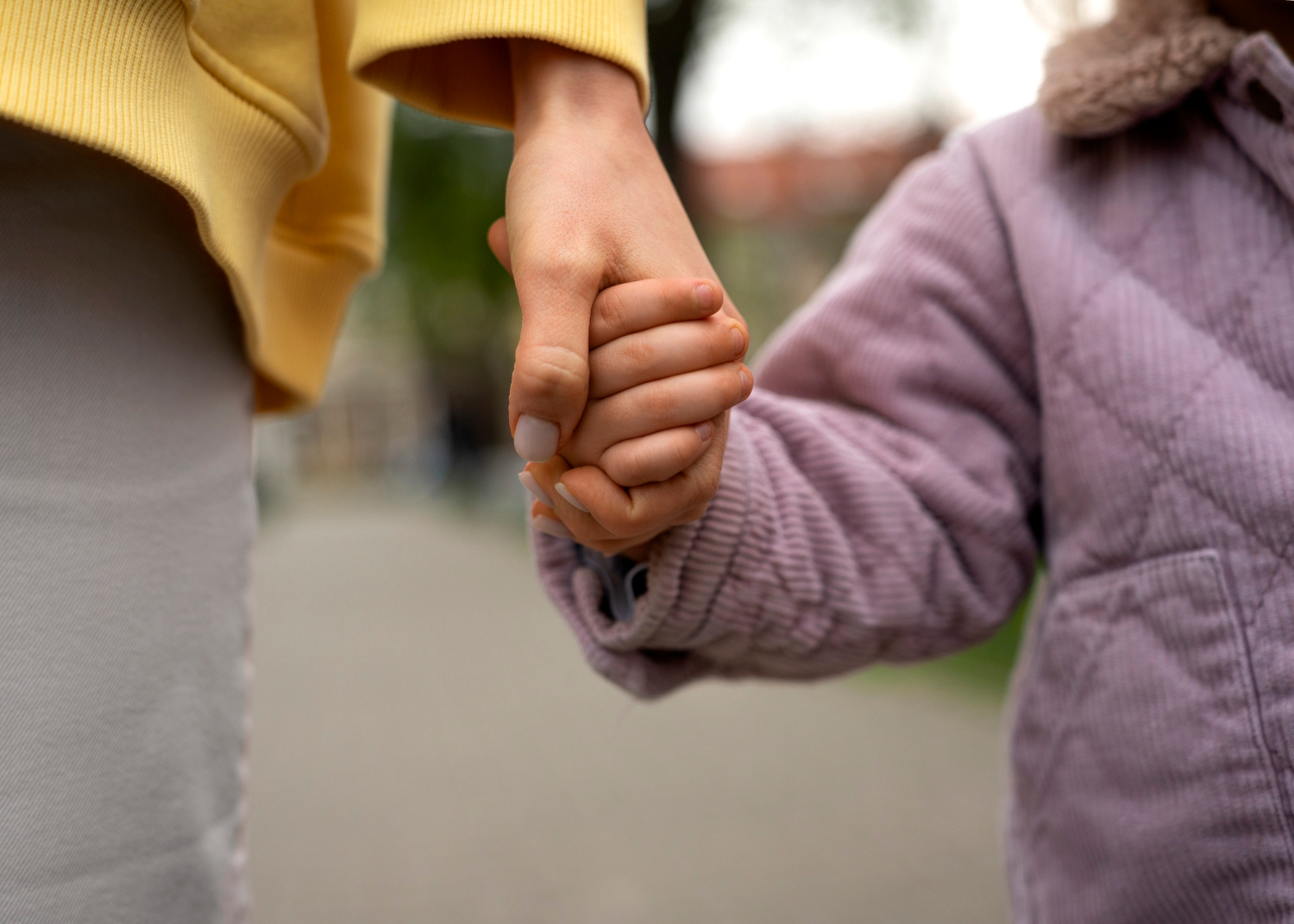 Una mujer tomando de la mano a una niña | Fuente: Freepik