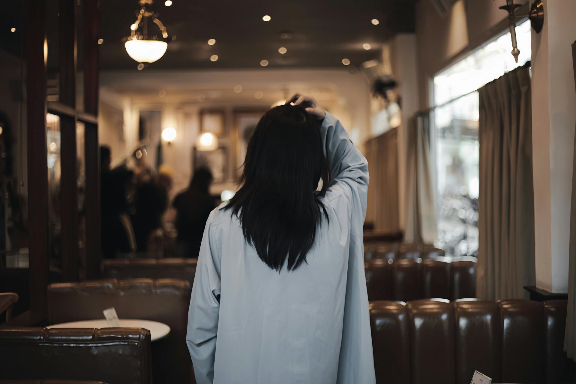 Vista trasera de una mujer caminando en un restaurante | Foto: Pexels