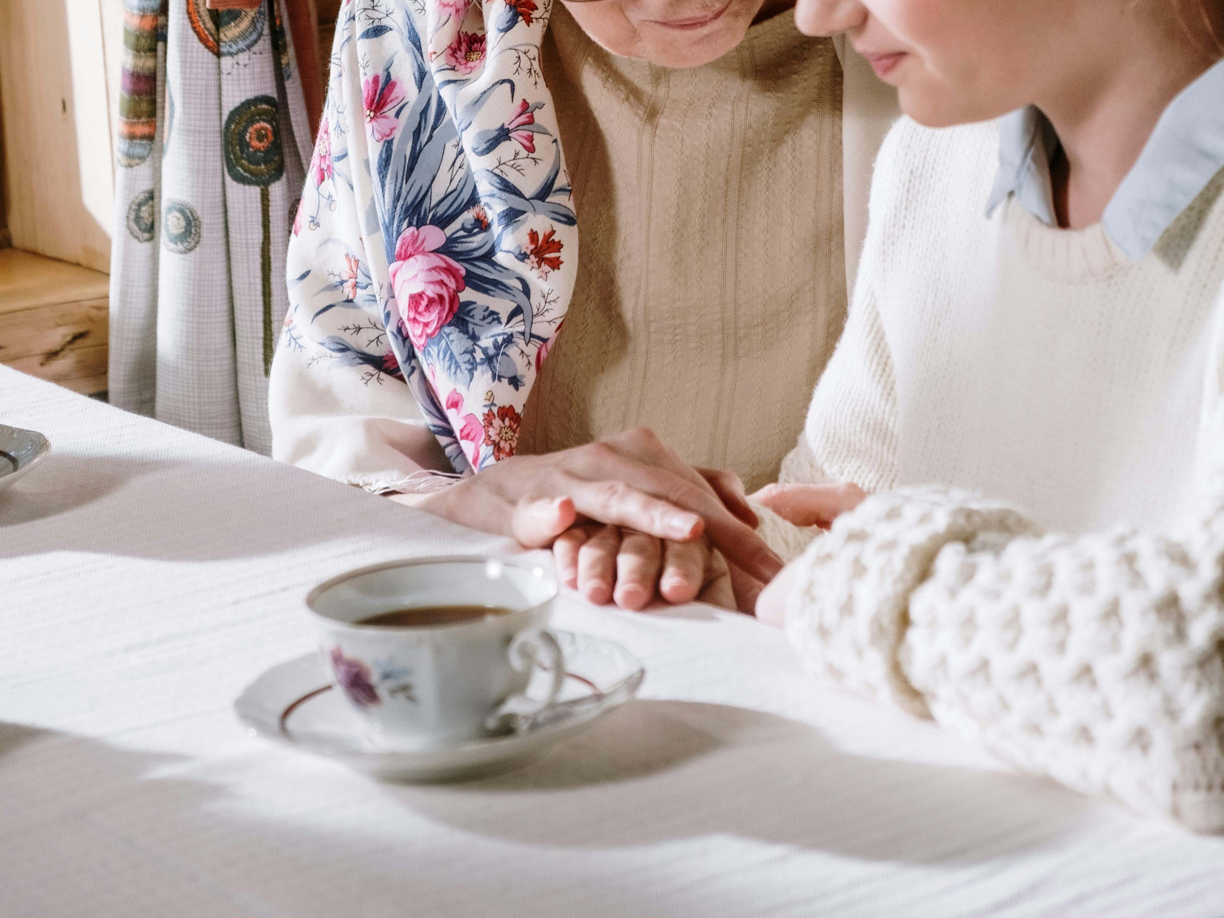 Una anciana cogida de la mano de una compañera más joven | Fuente: Pexels