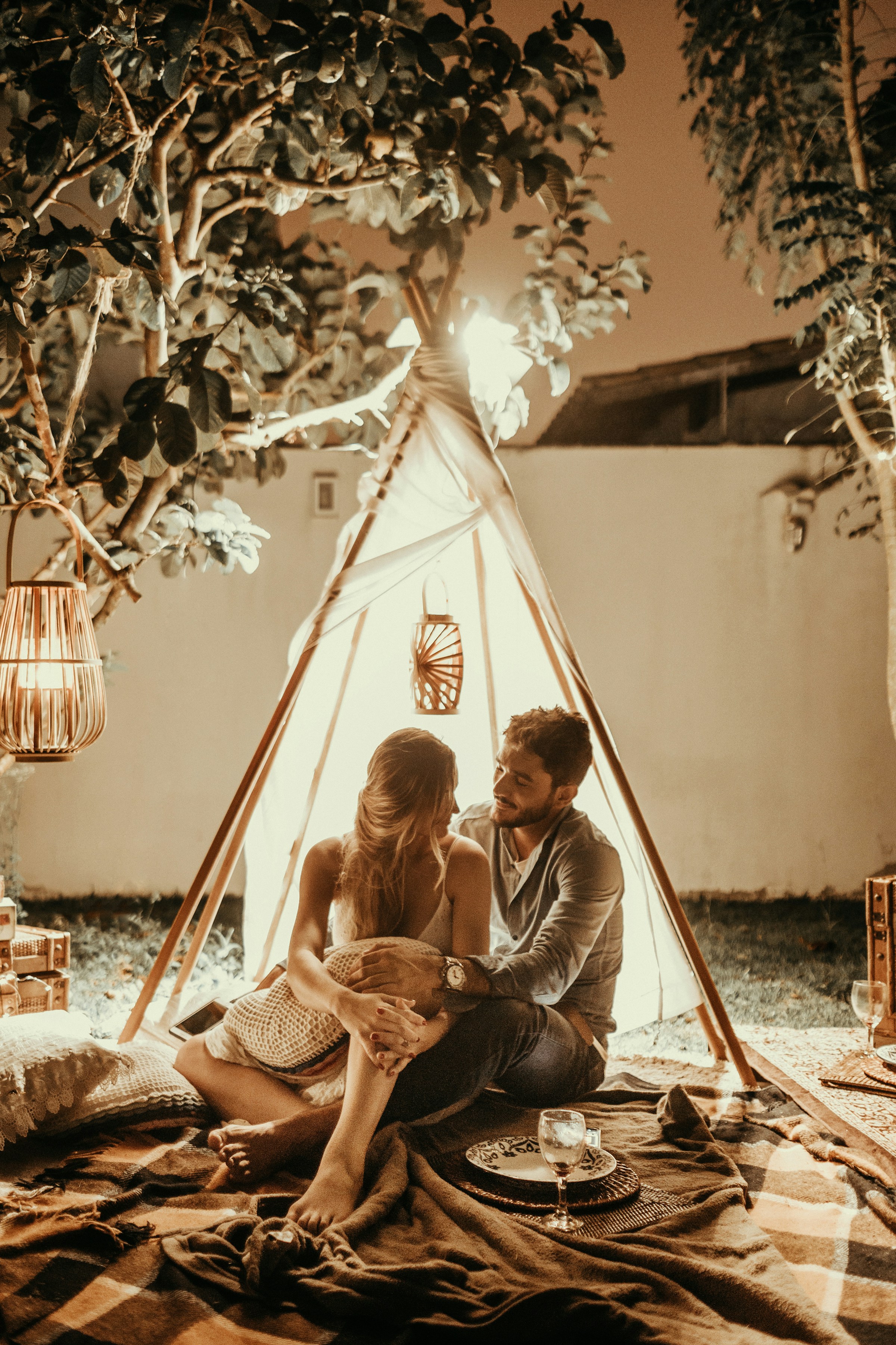 Una pareja sentada dentro de una cabaña tipi con luces | Foto: Unsplash