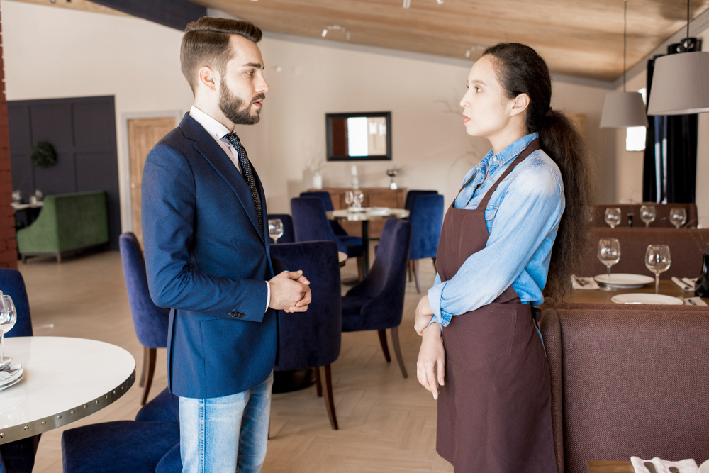 Un hombre hablando con un empleado de un restaurante | Fuente: Shutterstock