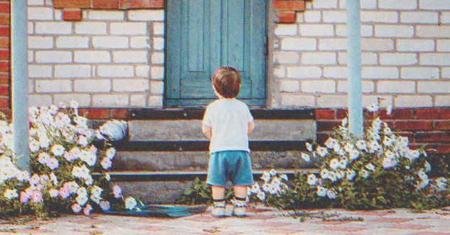 Un niño parado frente a la puerta de una casa | Foto: Shutterstock