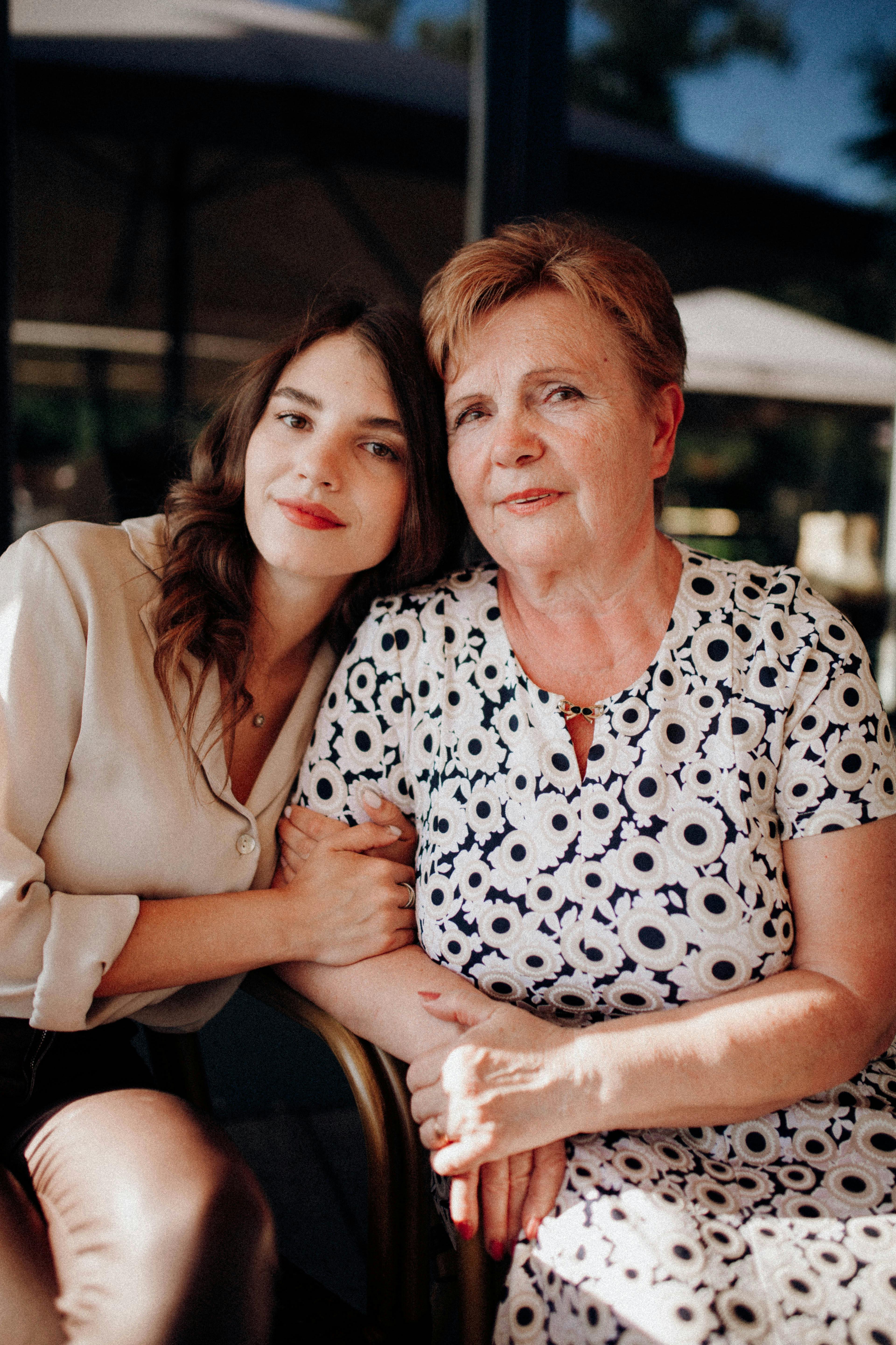 Niña sentada junto a su madre | Foto: Pexels