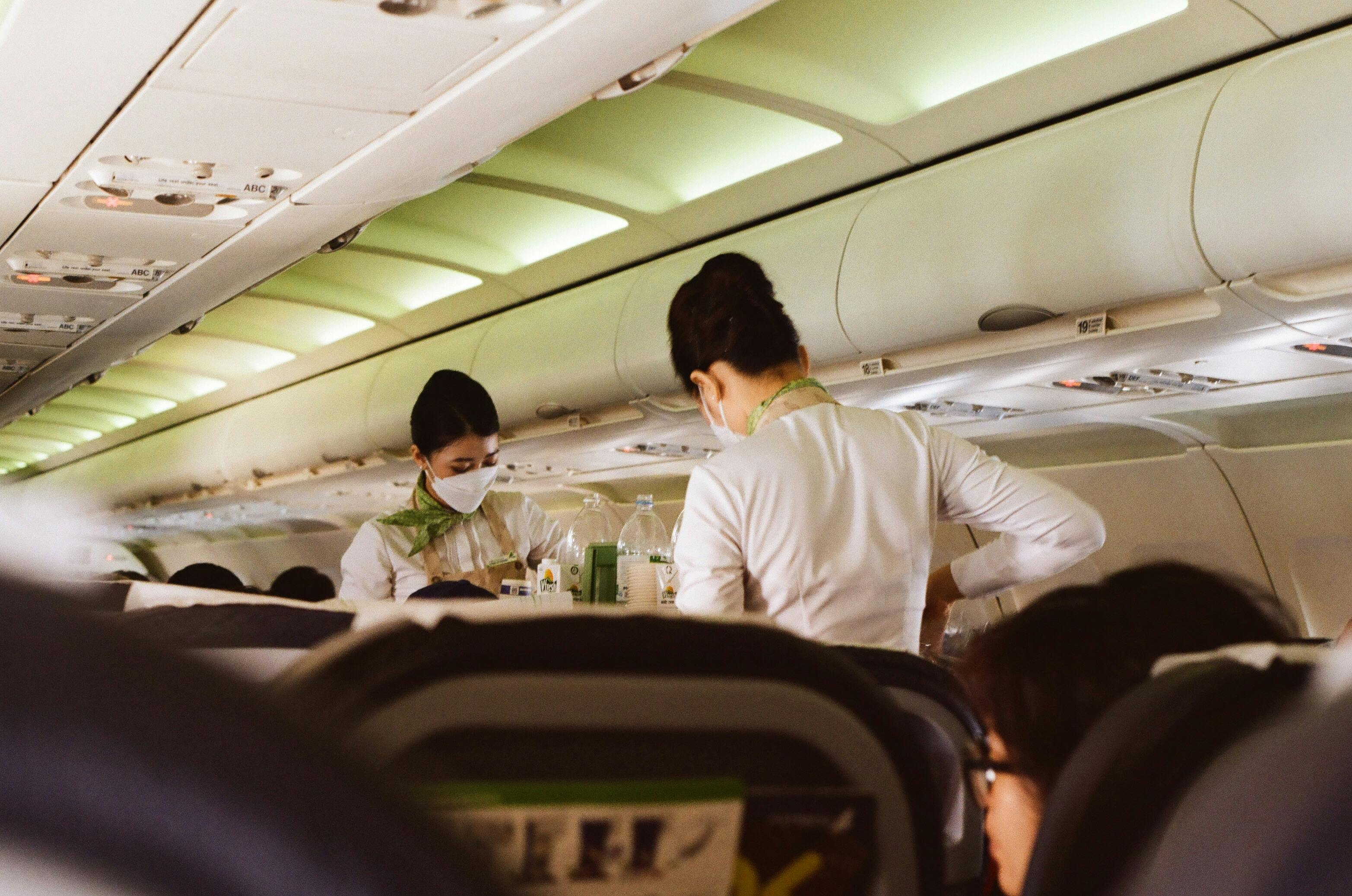 Dos auxiliares de vuelo atendiendo a los pasajeros | Fuente: Pexels