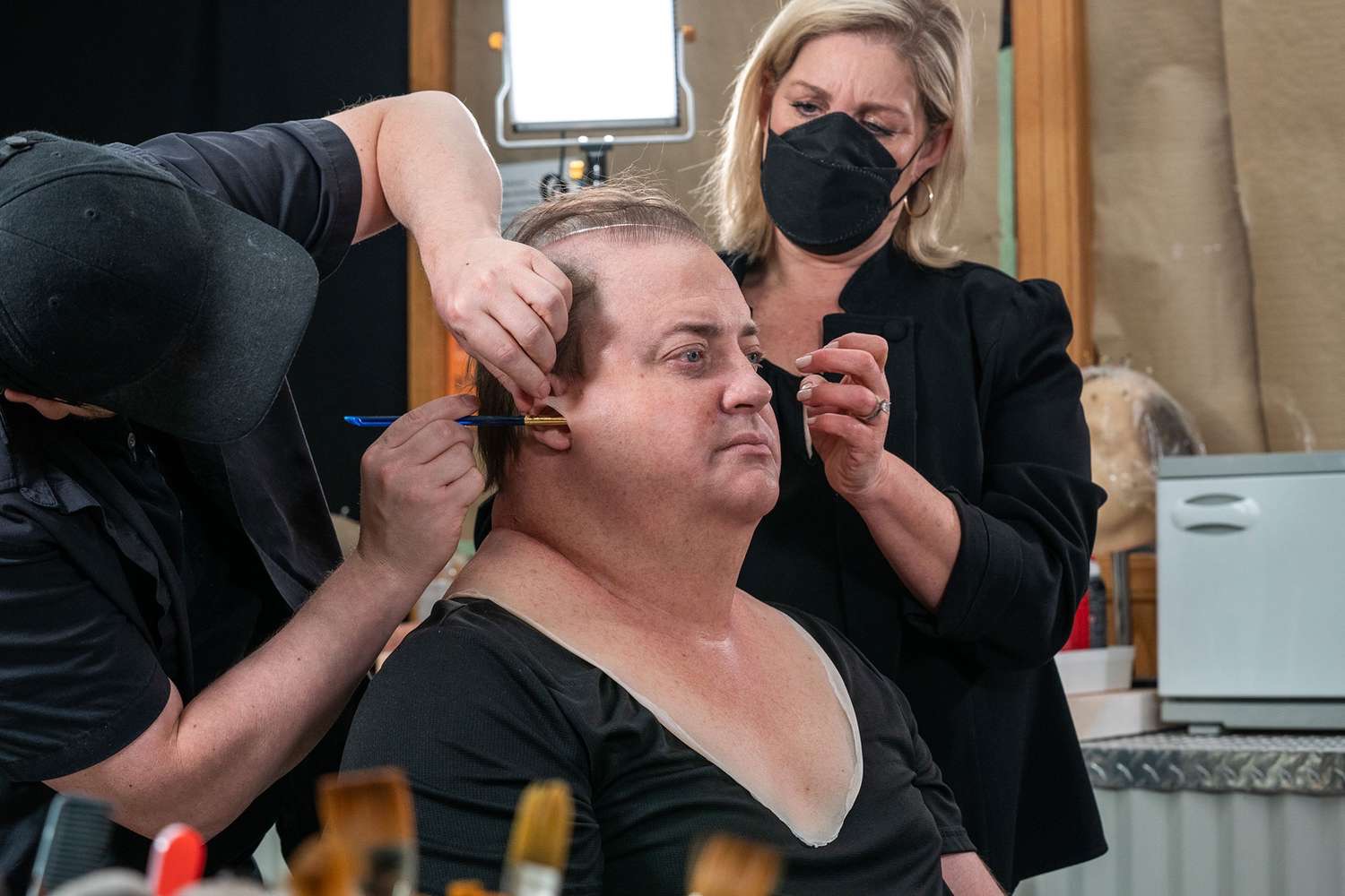 Brendan Fraser en plena transformación para meterse en la piel de Charlie en "The Whale", mientras los maquilladores le aplican prótesis que tardaron varias horas en terminar y que ayudaron a crear la apariencia del personaje, que pesa 600 libras. | Fuente: Getty Images