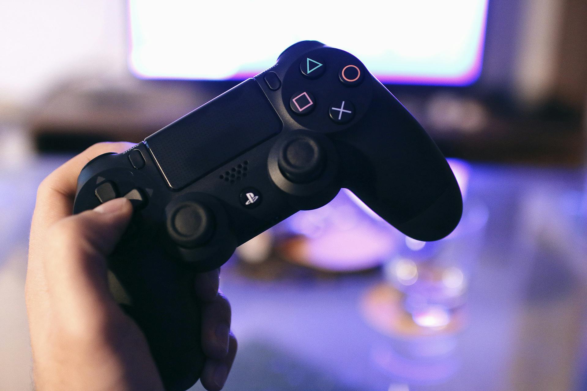 Un hombre sujetando un mando de PlayStation | Fuente: Pexels