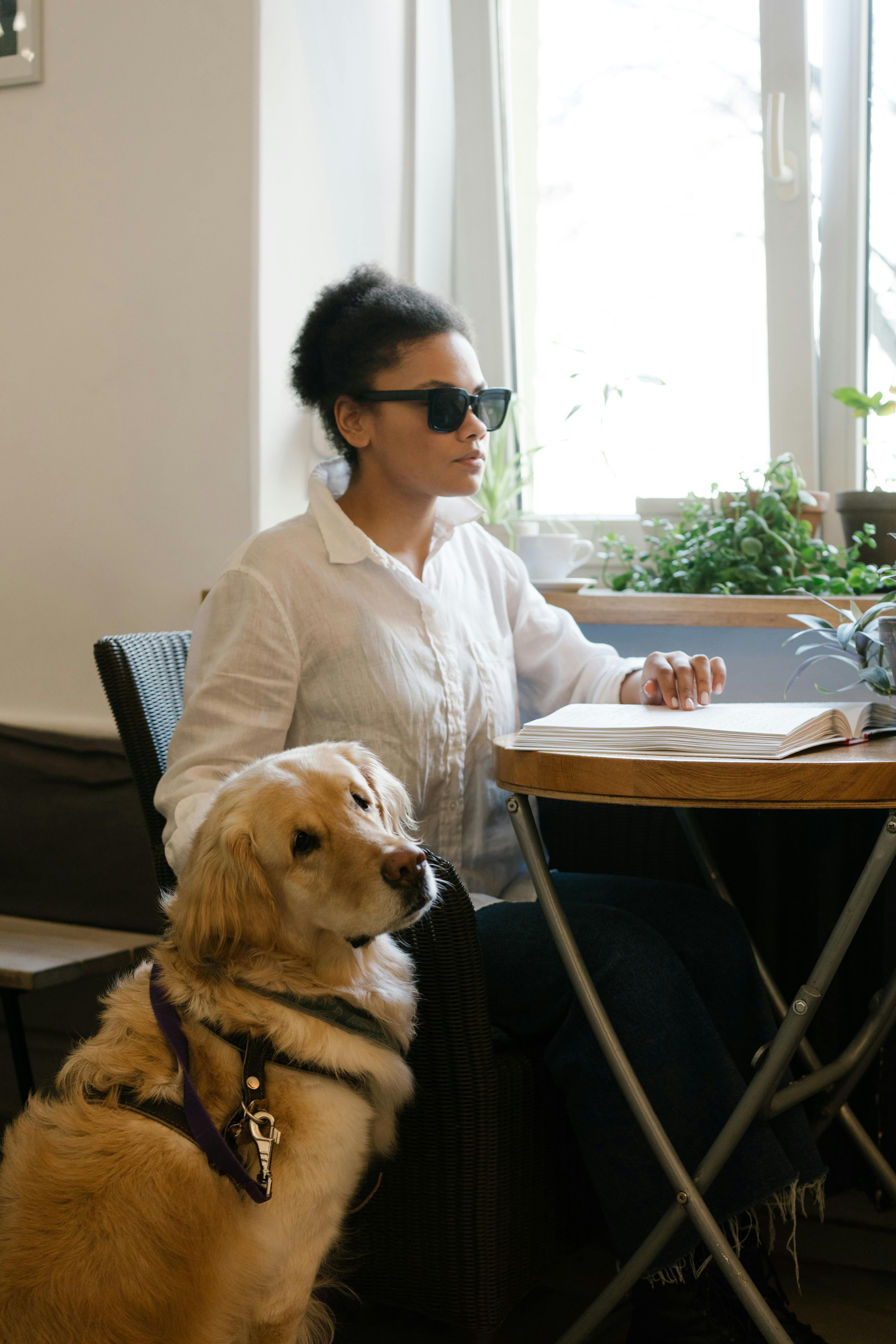 Mujer invidente leyendo braille en un café | Foto: Pexels