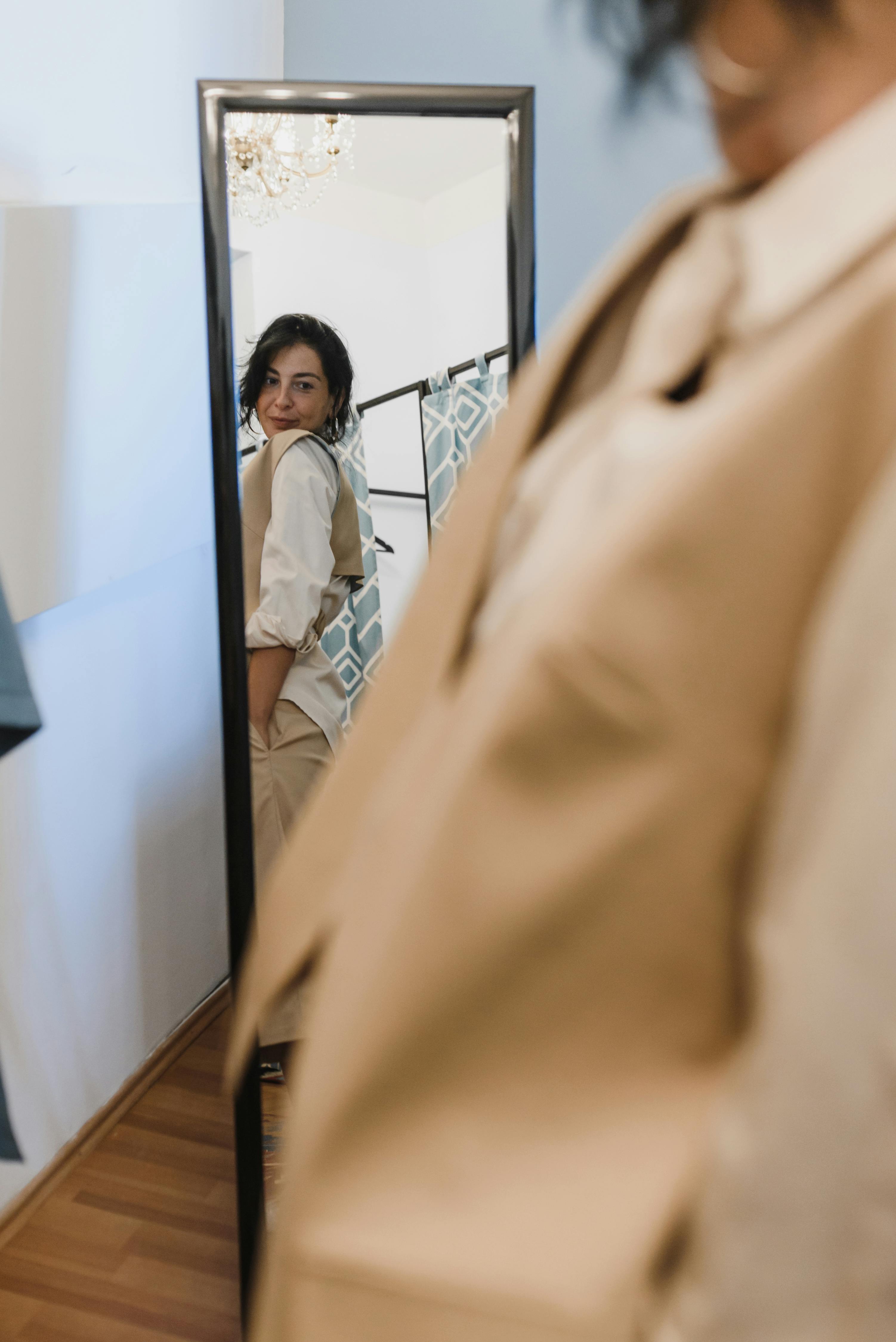 Una mujer comprueba su atuendo en el espejo. | Foto: Pexels
