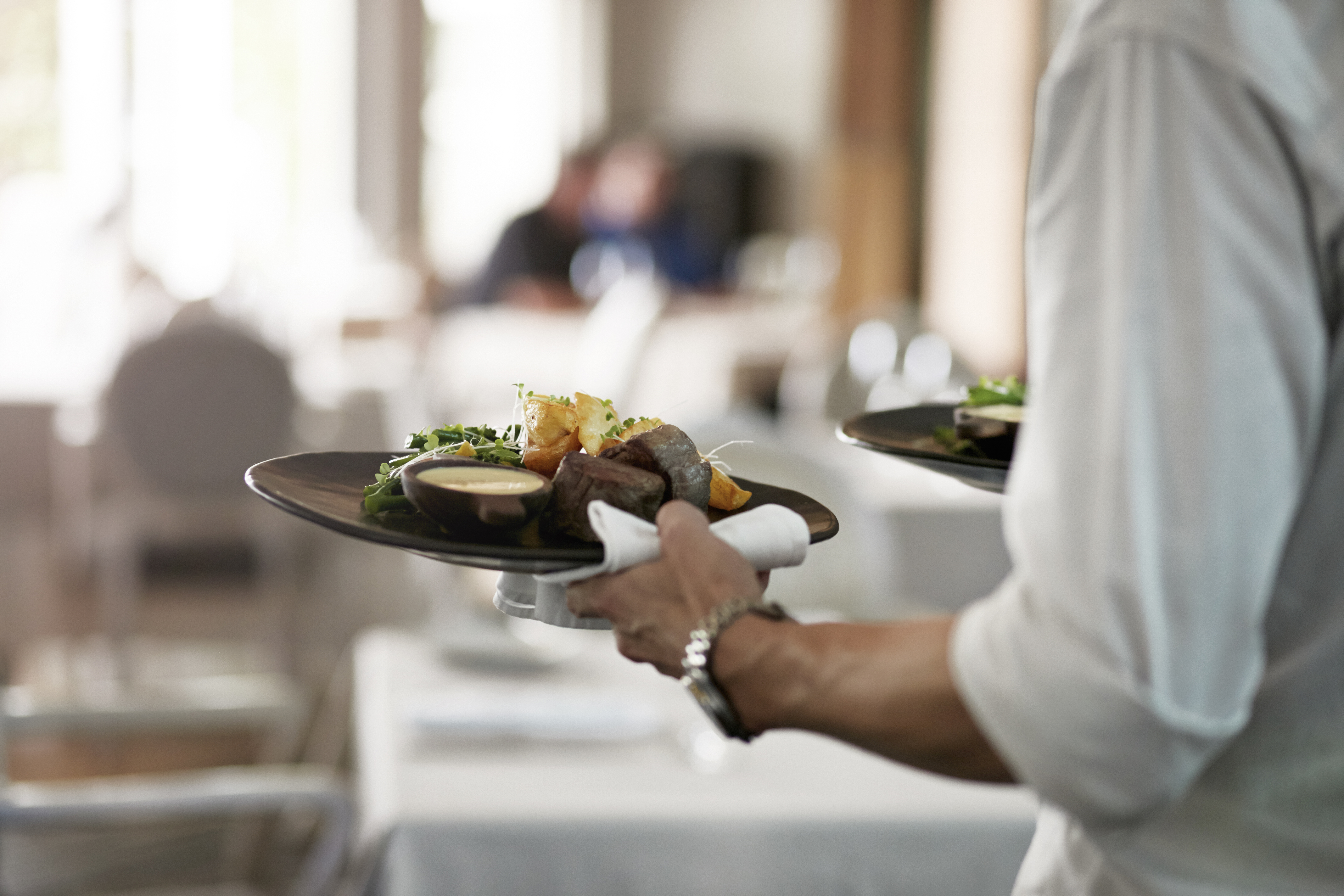 Camarero llevando platos llenos de comida | Foto: Getty Images