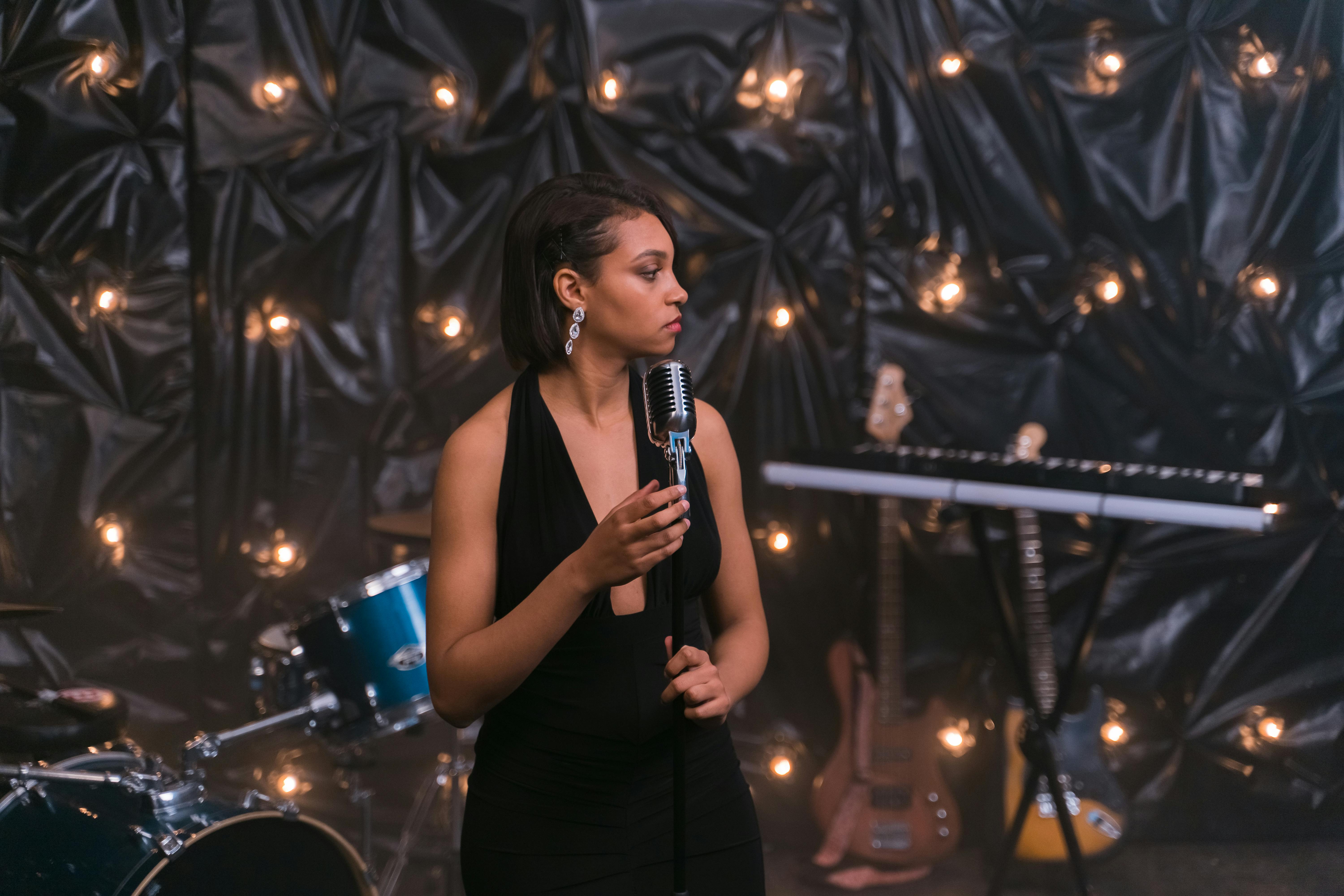 Una mujer hablando por un micrófono en el escenario | Fuente: Pexels