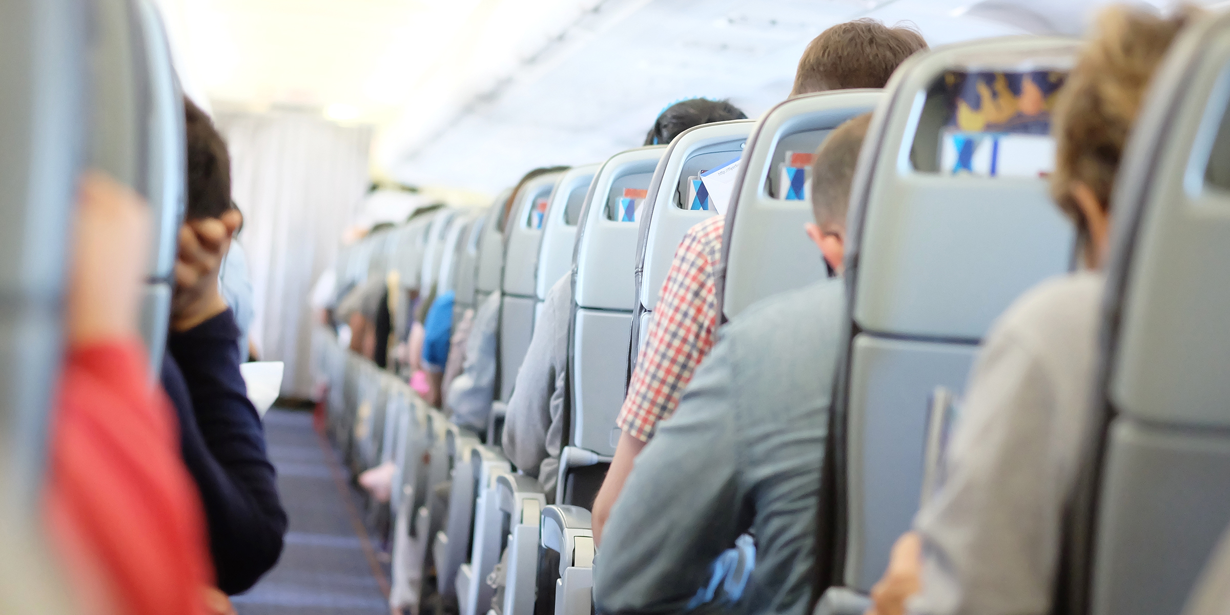 Pasajeros sentados en clase turista durante un vuelo comercial | Fuente: Shutterstock