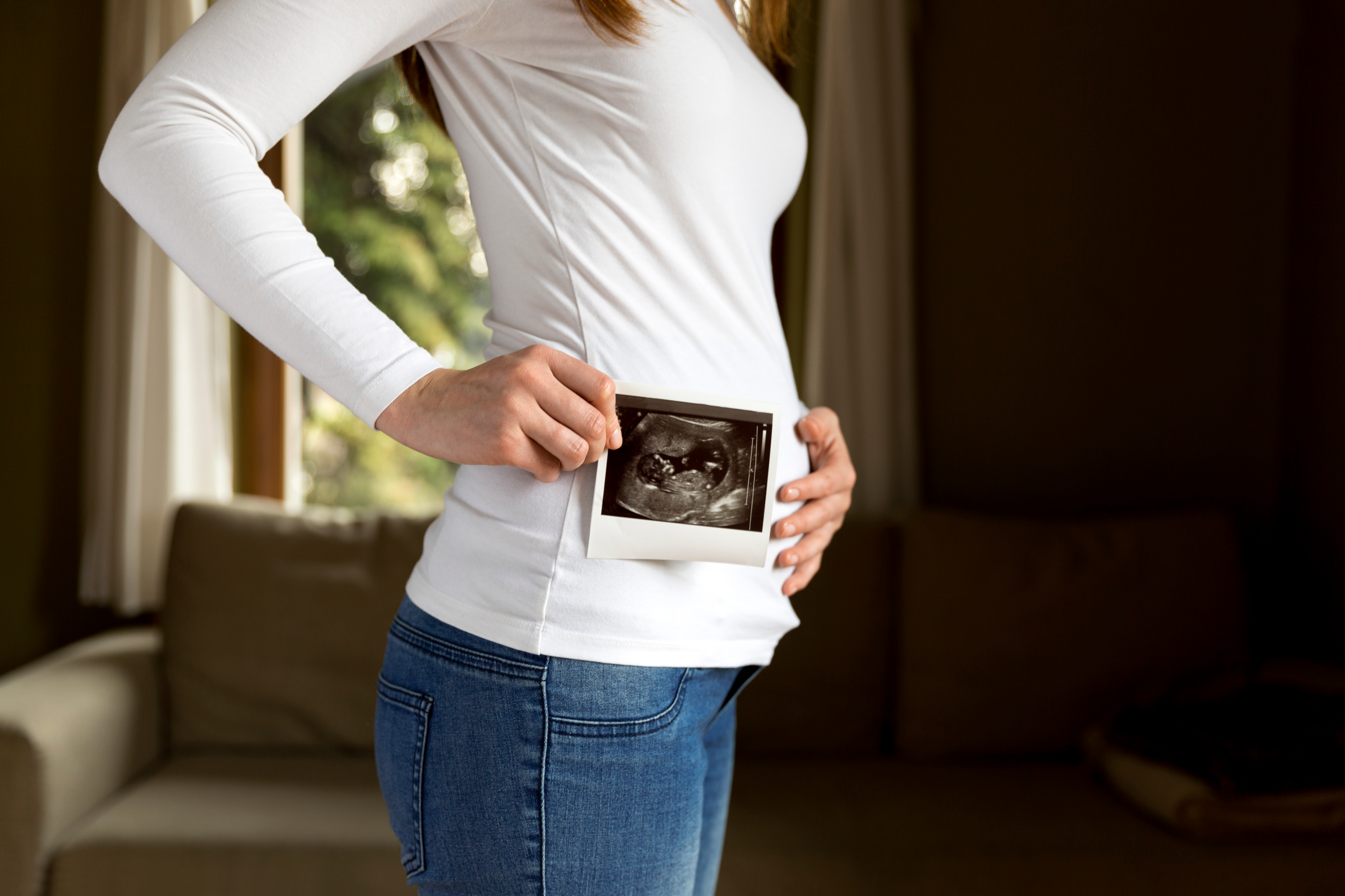 Una mujer embarazada sosteniendo una ecografía | Fuente: Shutterstock