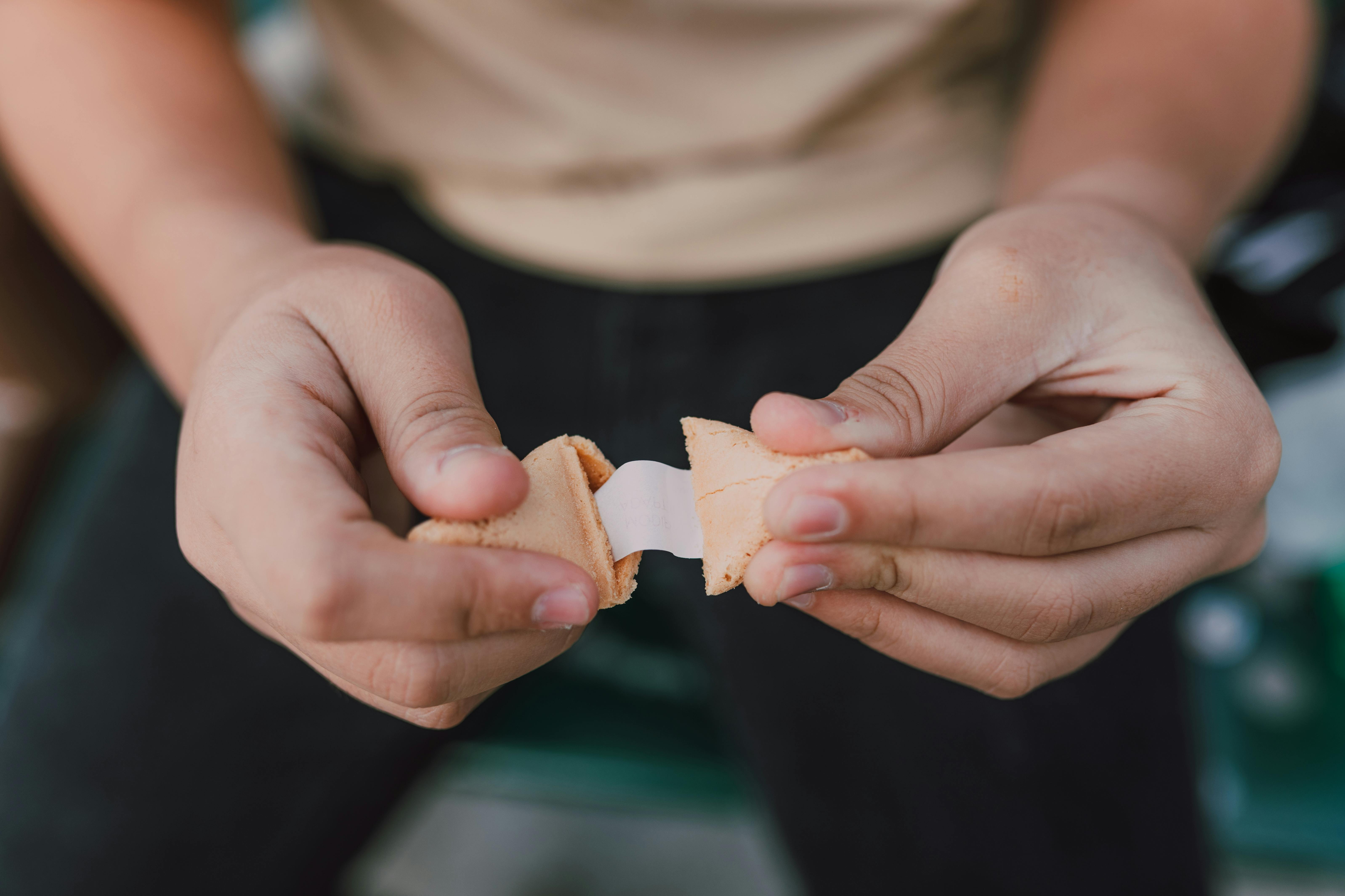 Abriendo una galleta de la suerte | Fuente: Pexels