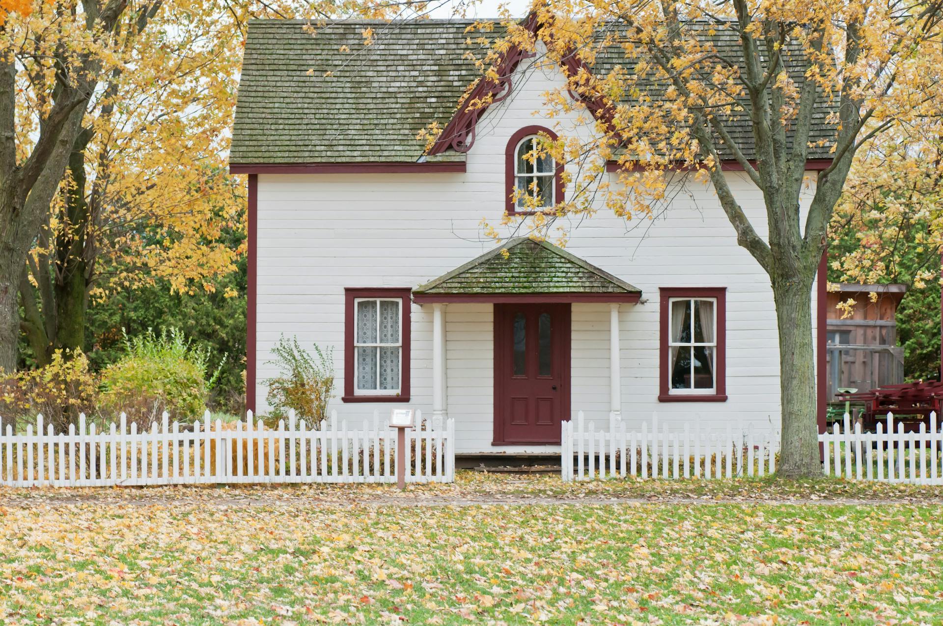 Una casa con una valla blanca | Fuente: Pexels