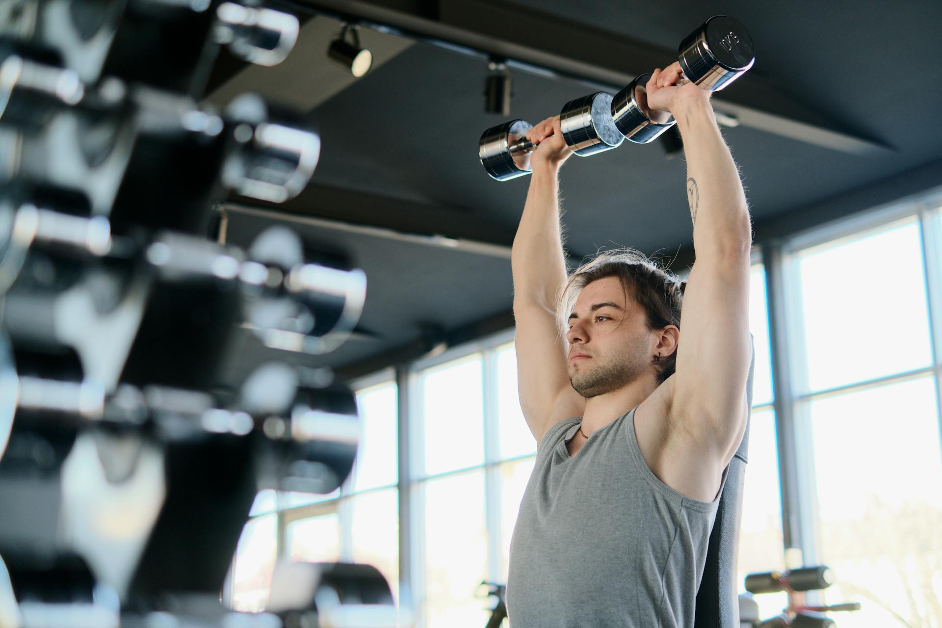 Un hombre haciendo ejercicio con mancuernas en un gimnasio | Fuente: Pexels