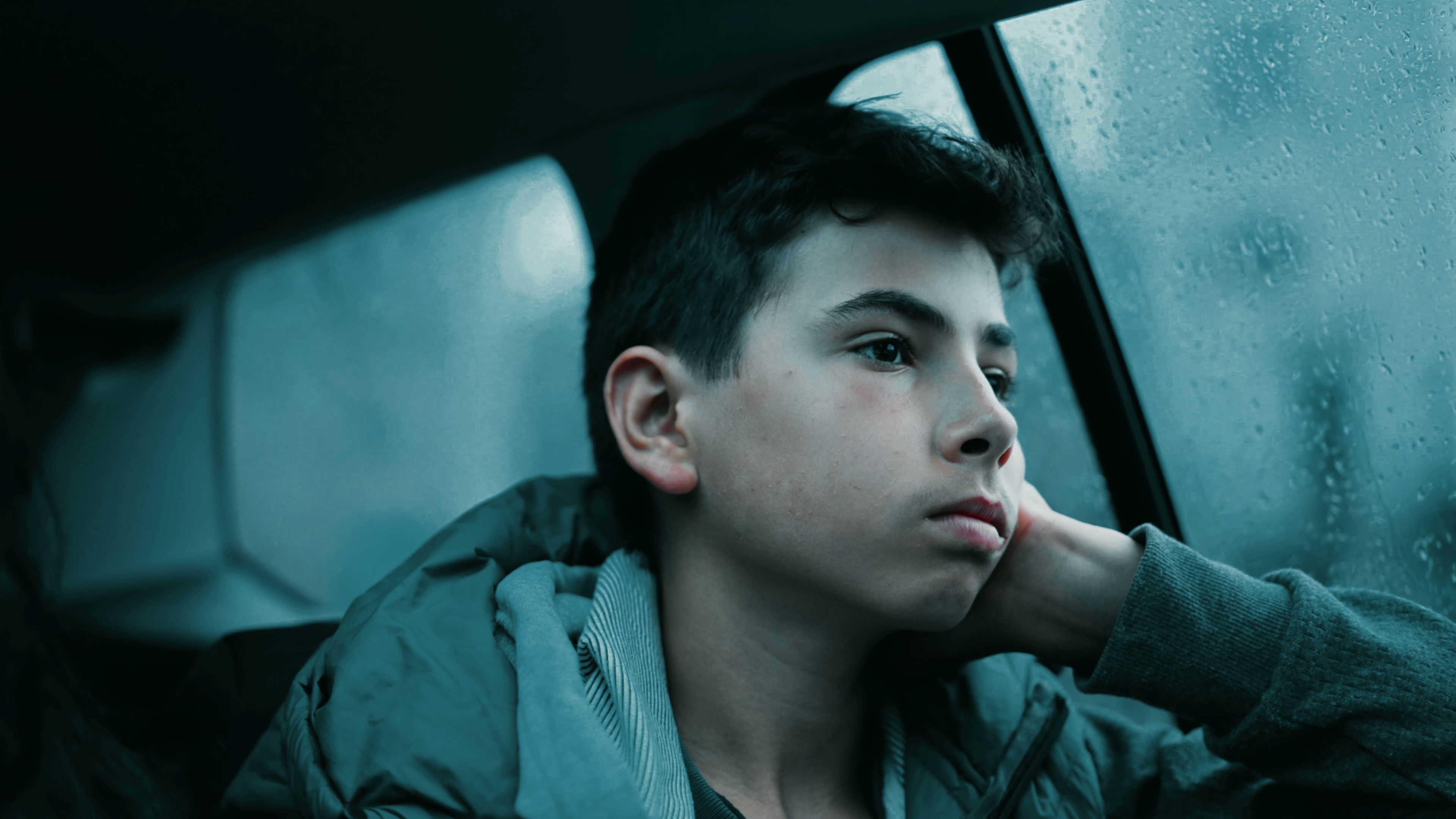 Un niño triste está sentado cerca de la ventanilla de un automóvil | Fuente: Shutterstock.com