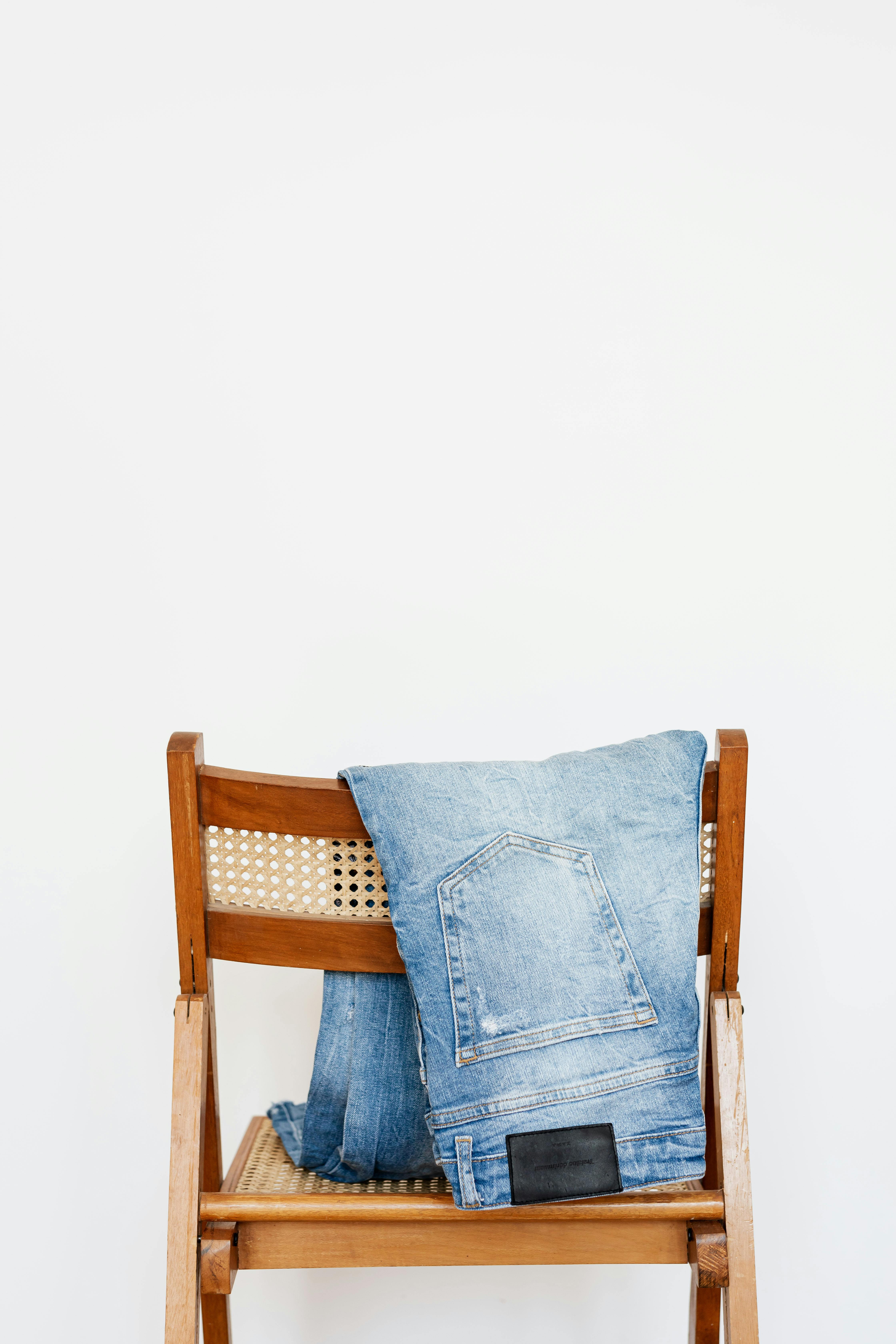 Unos jeans colgados de una silla | Fuente: Pexels