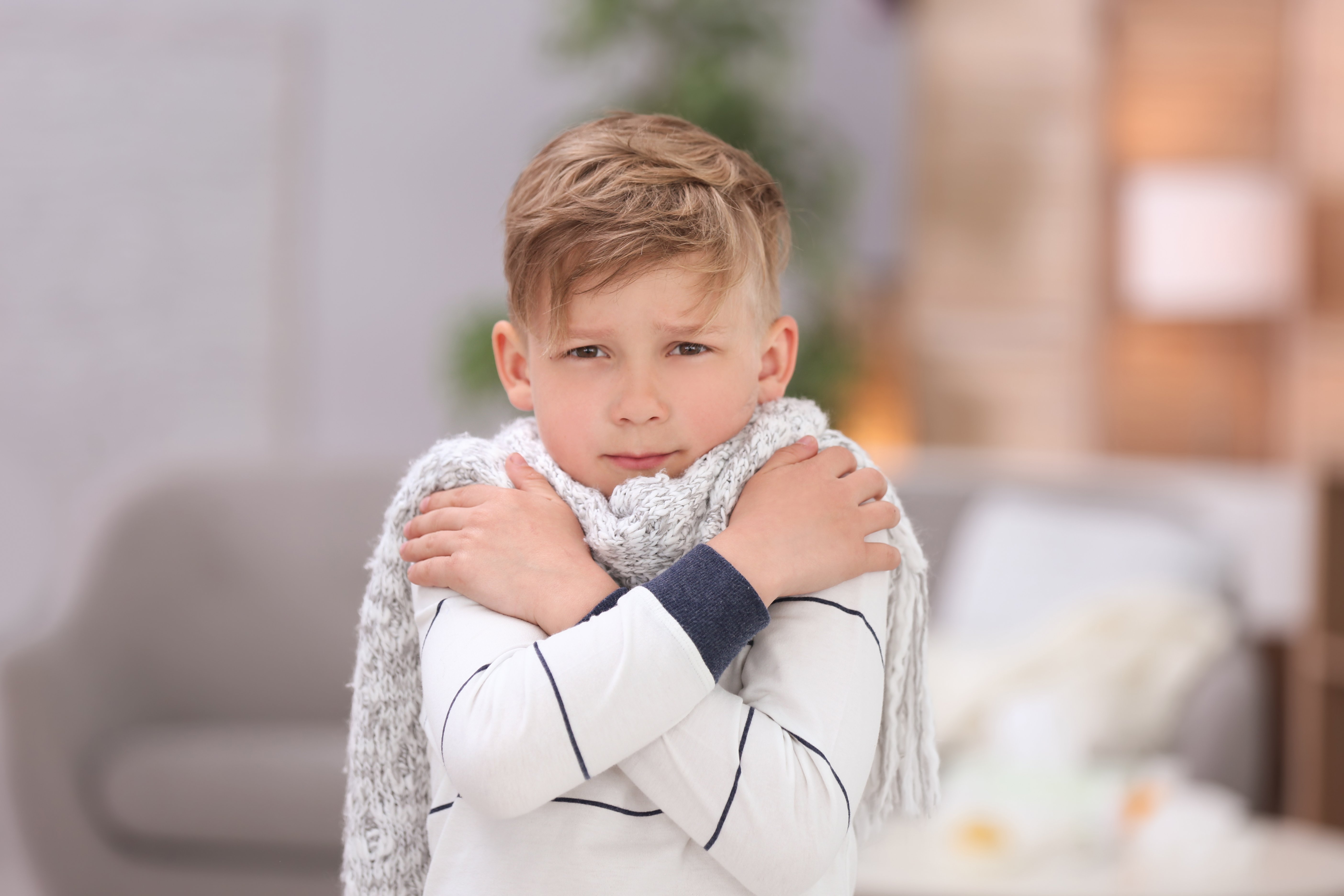 Niño abrigado con sus manos sobre sus hombros. | Foto: Shutterstock