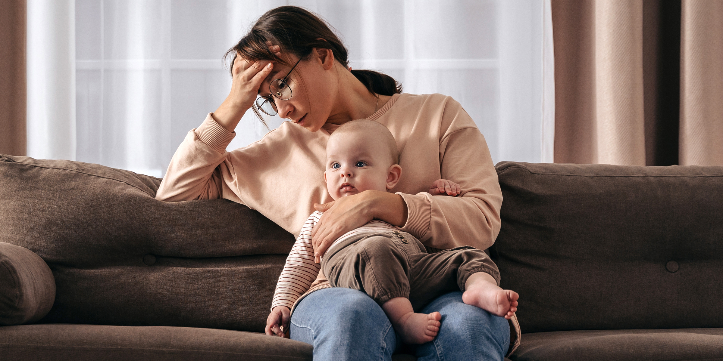 Una mujer triste con un bebé en el regazo | Fuente: Shutterstock