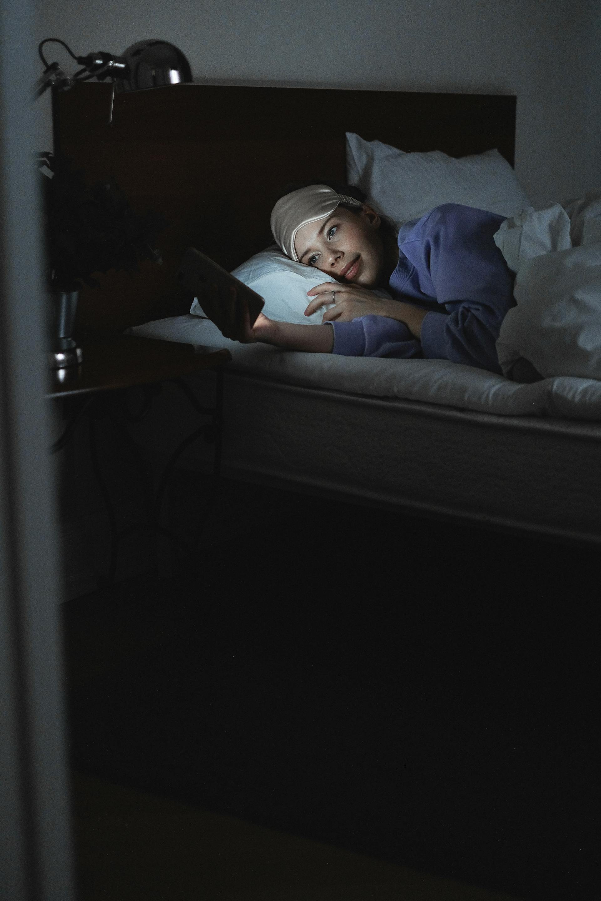 Una mujer usando su teléfono en la cama | Fuente: Pexels