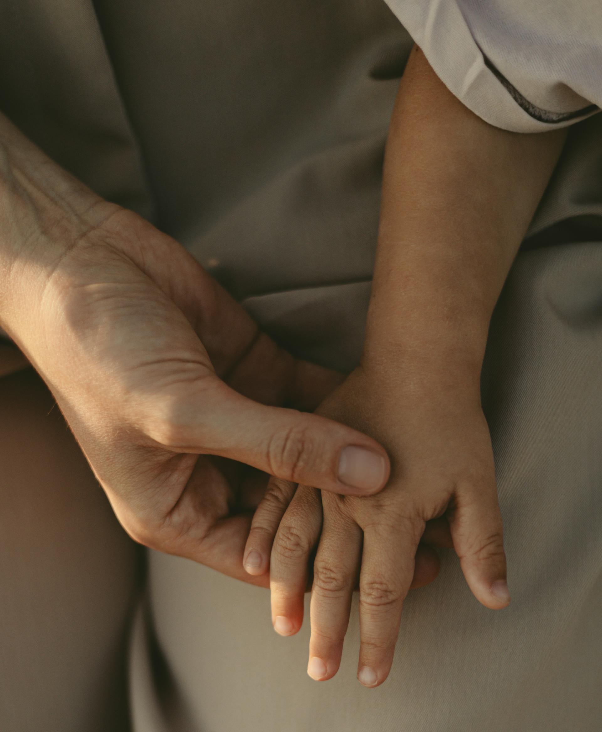 Una persona cogiendo de la mano a un niño | Fuente: Pexels