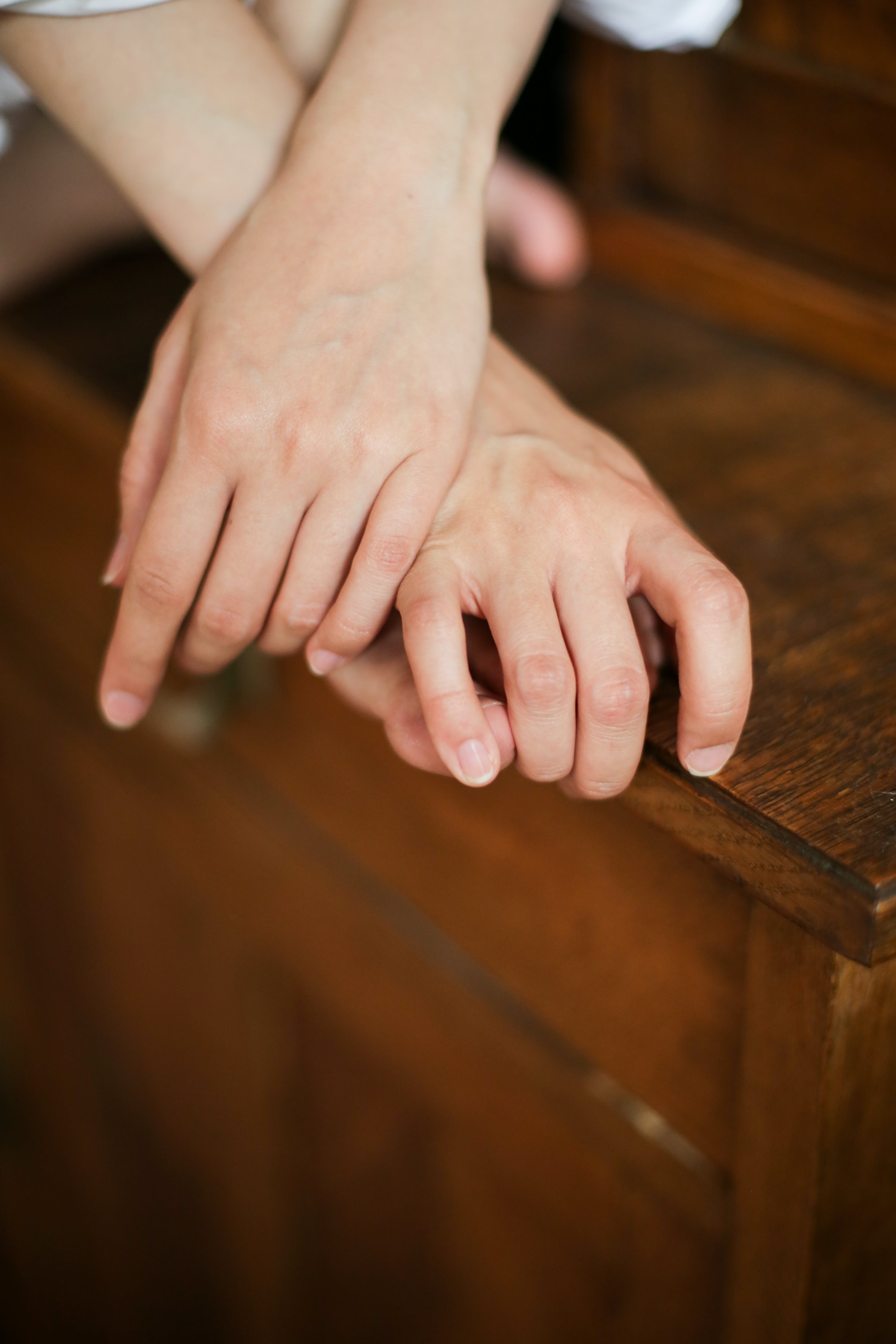 Las manos de una persona sobre una mesa de madera. | Fuente: Pexels