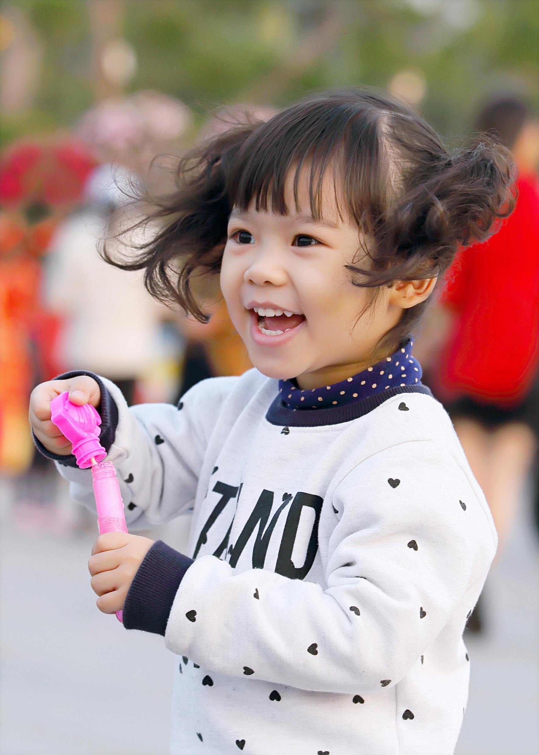 Una niña sonriendo mientras juega | Fuente: Pexels