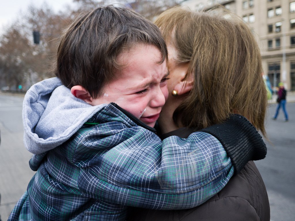Mujer sosteniendo en brazos a un niño llorando. | Imagen: Flickr