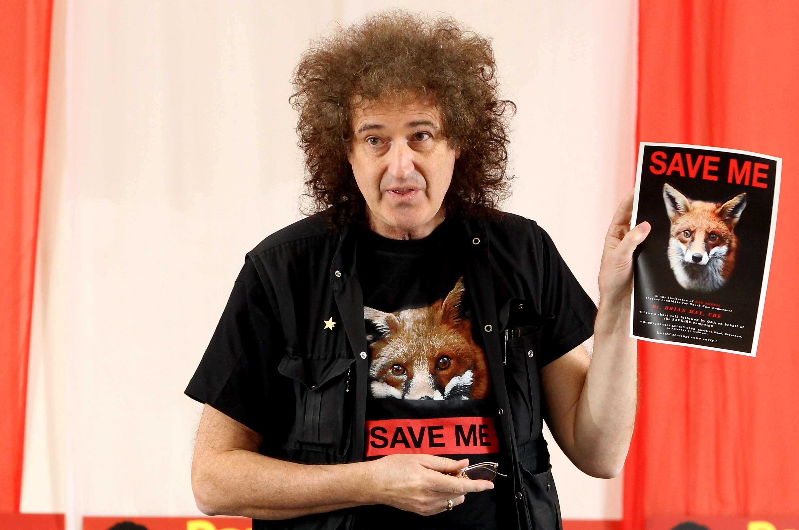 Brian May sostiene un cartel contra la caza del zorro en la Royal British Legion de Keynsham, Inglaterra, el 24 de abril de 2010.