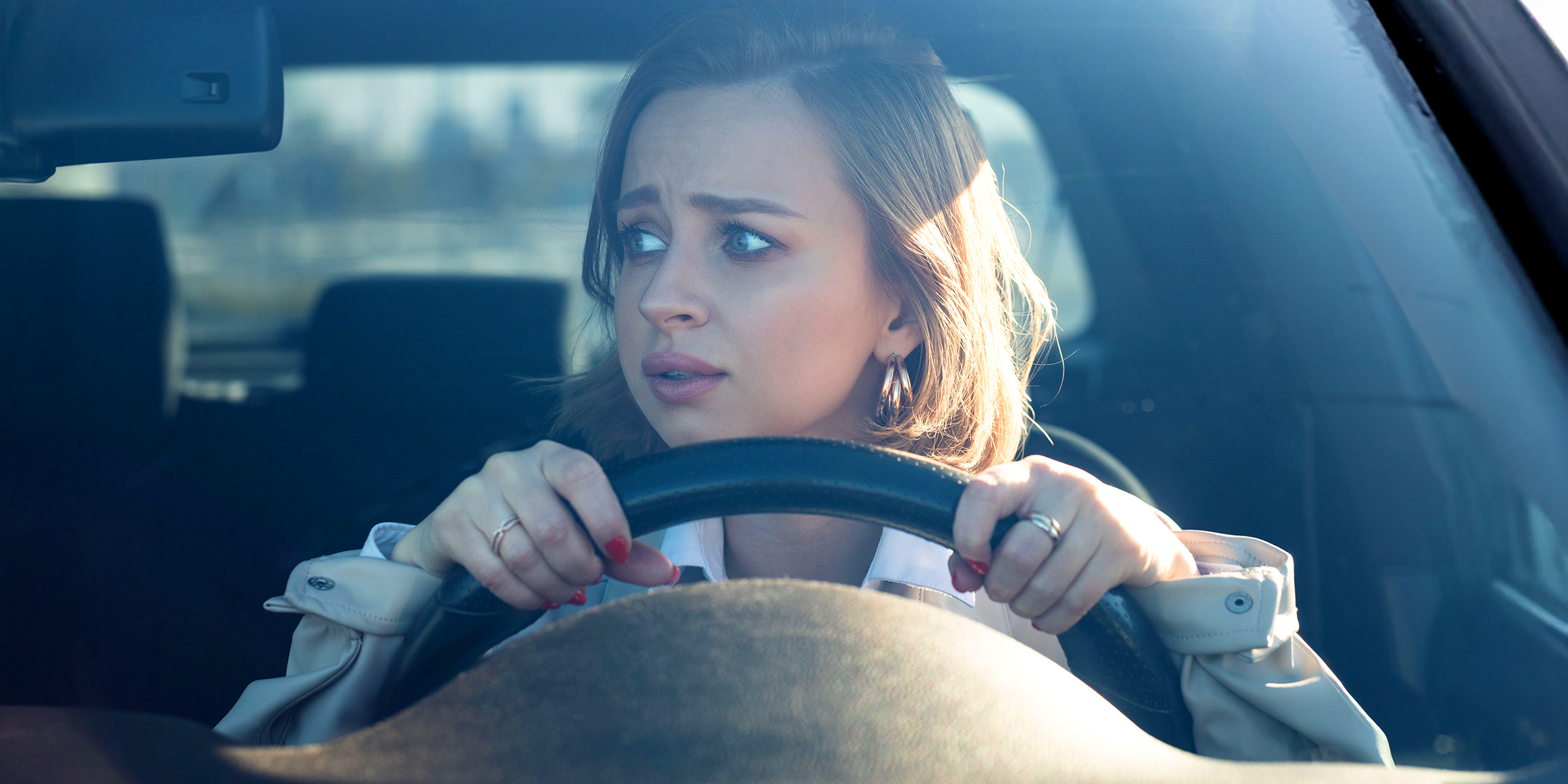 Mujer joven nerviosa al volante | Fuente: Shutterstock