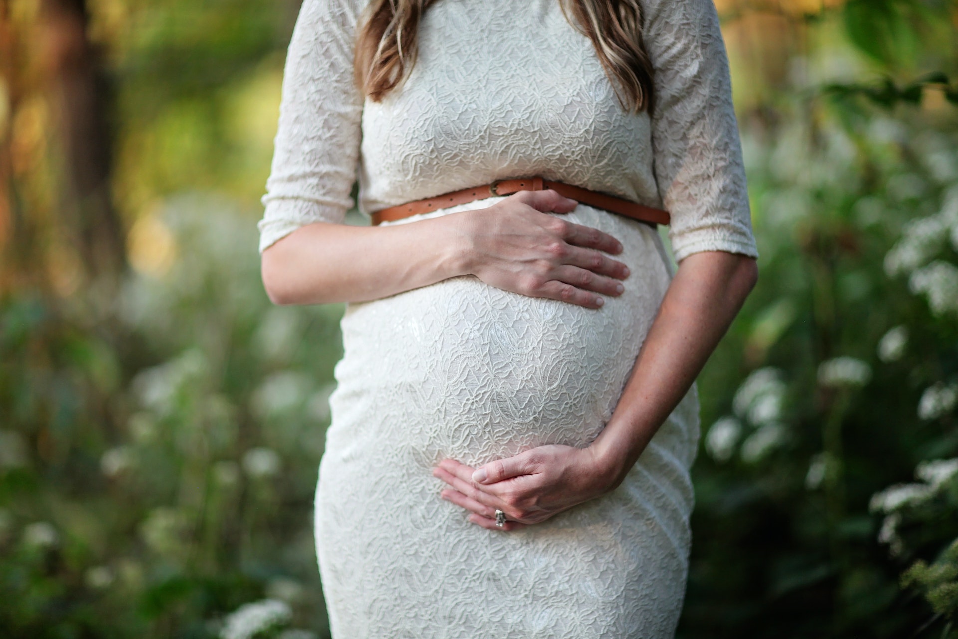 Una mujer embarazada rodeando su barriguita. | Foto: Pexels