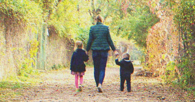 Una mujer caminando con dos niños de la mano | Foto: Shutterstock