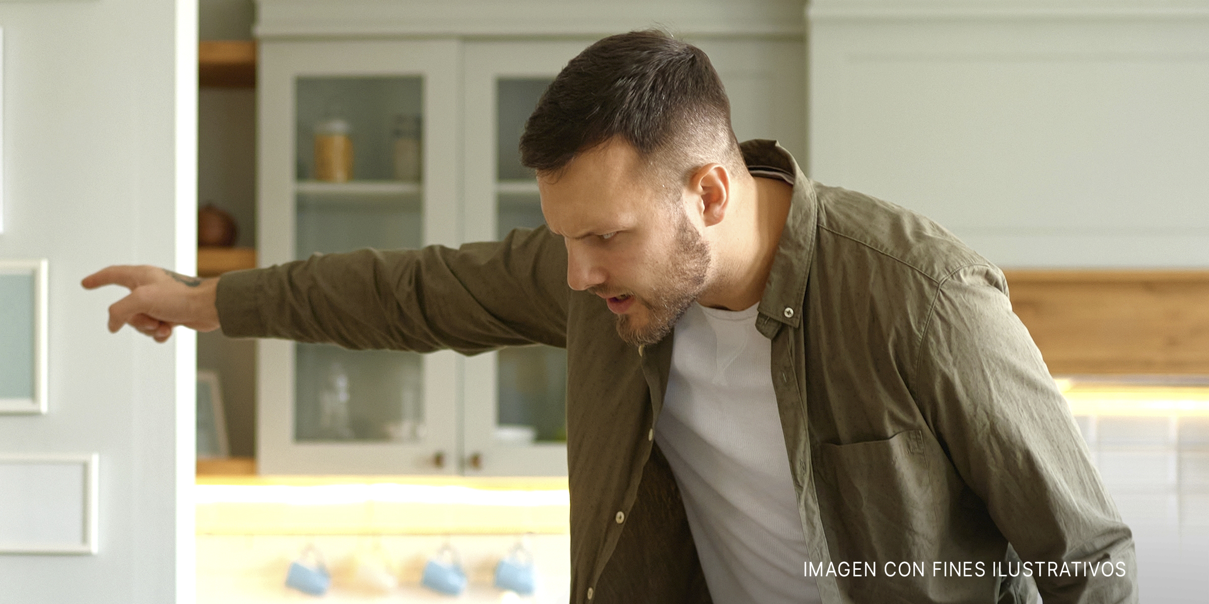 Un hombre señala enfadado hacia otro lado mientras habla con alguien | Fuente: Shutterstock