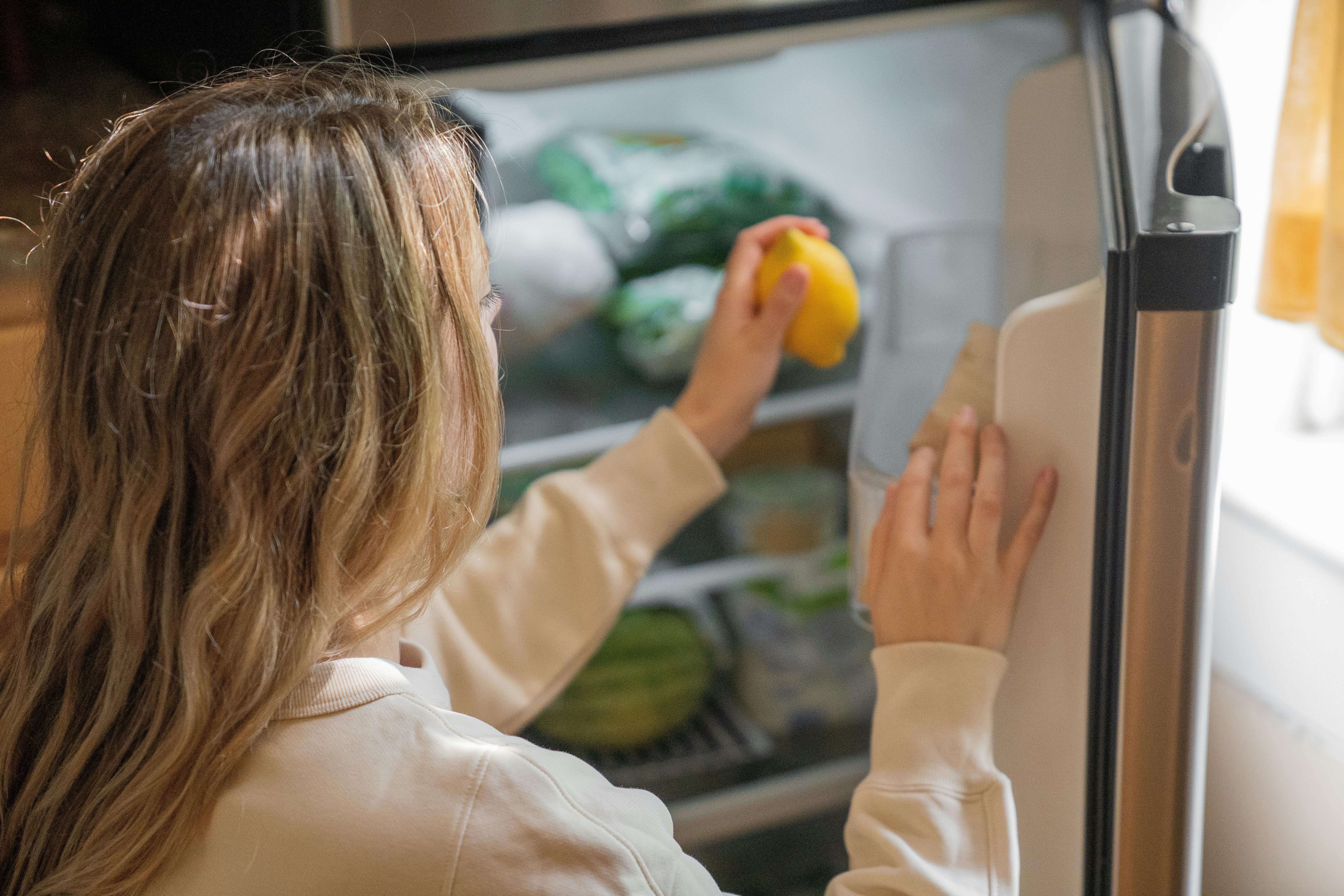 Una mujer metiendo comida en la nevera | Fuente: Pexels