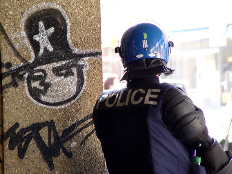 Oficial de policía con un casco resguardándose. | Foto: Wikimedia Commons