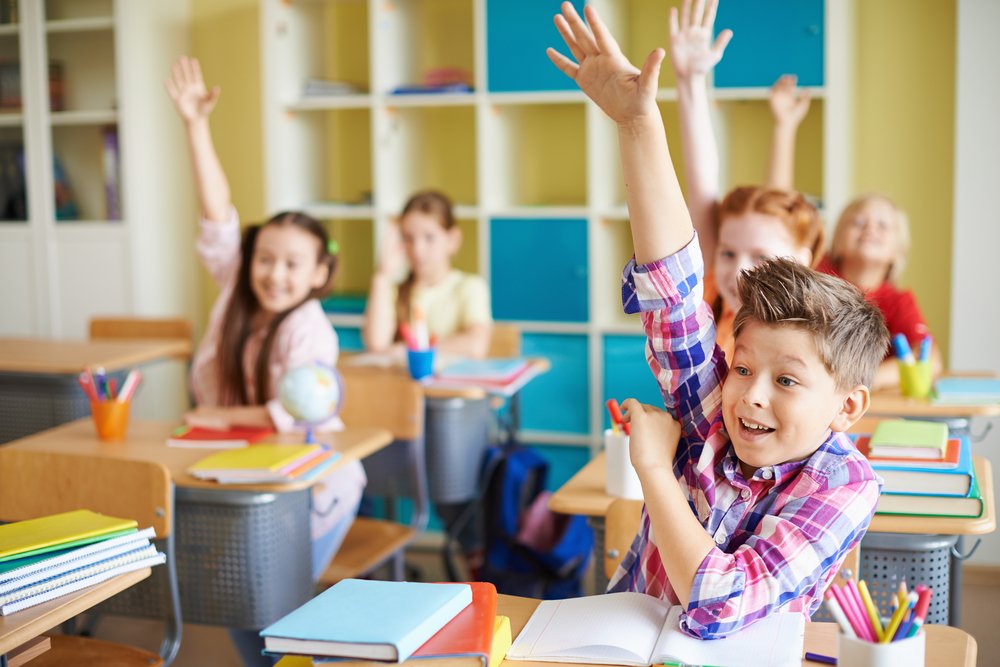 Niños levantando la mano en clases. | Foto: Shutterstock.