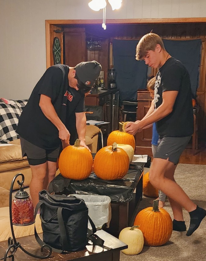 Ayden Beeson y un compañero tallando calabazas en una foto subida el 28 de junio de 2024 | Fuente: Facebook/Ashley Edwards