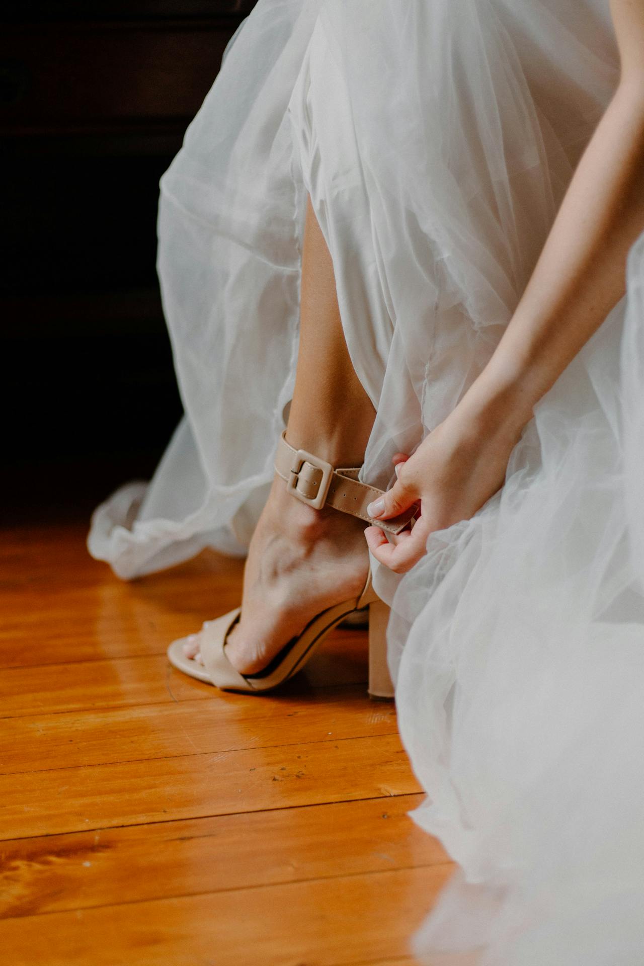 Una novia desatándose los tacones | Fuente: Pexels