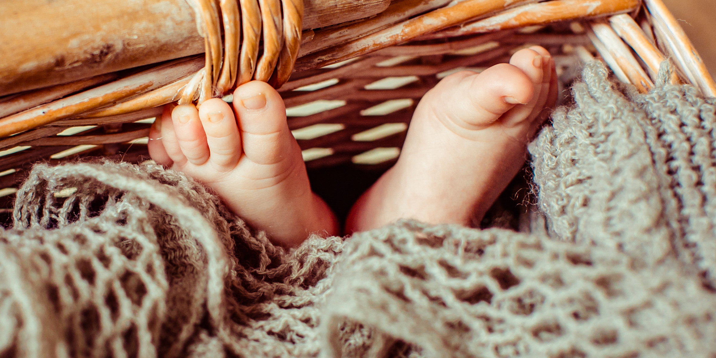 Pies de un bebé tumbado en una cesta | Fuente: Shutterstock