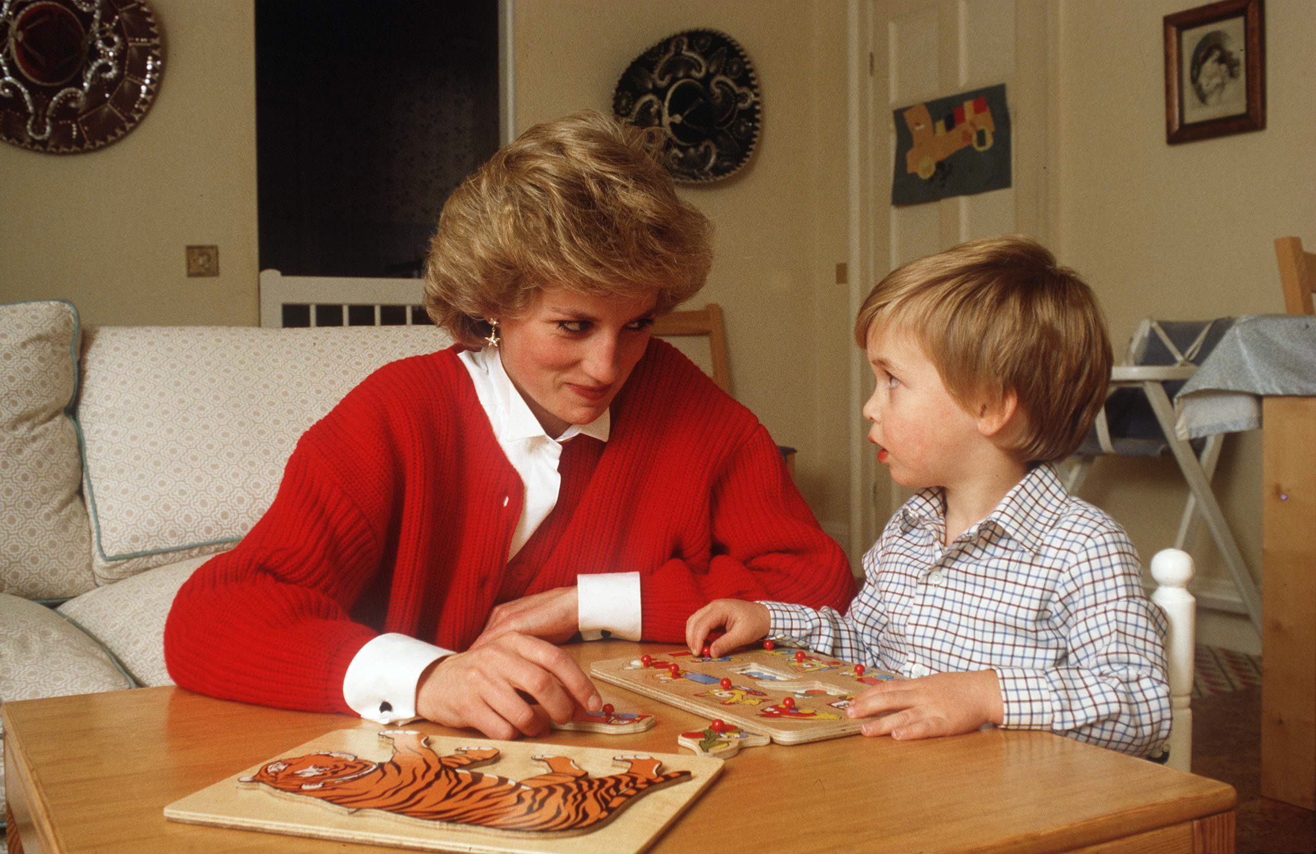 La princesa Diana ayudando al príncipe William con un rompecabezas en su sala de juegos en el Palacio de Kensington. | Foto: Getty Images