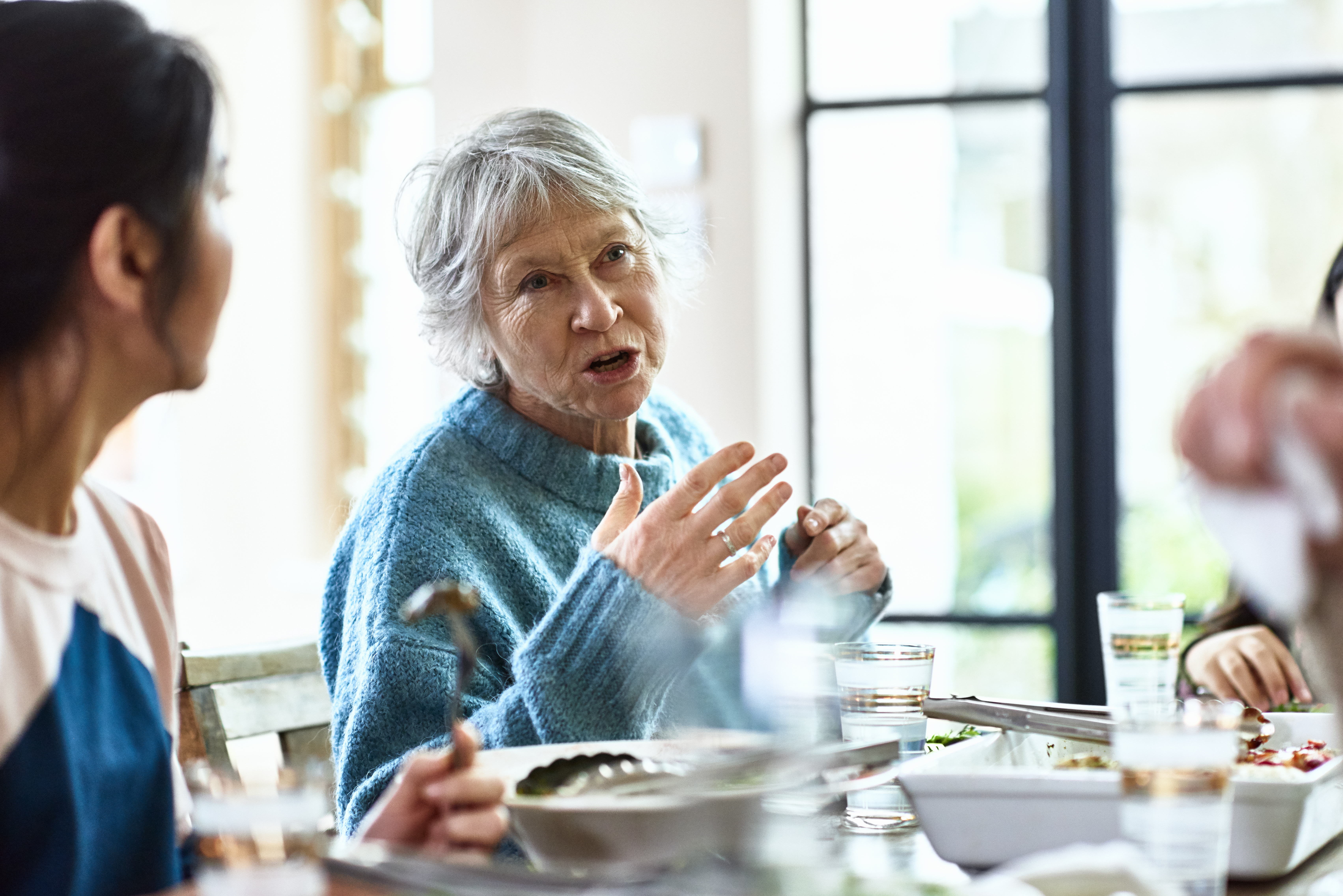 Una abuela contando historias en la mesa | Foto: Getty Images