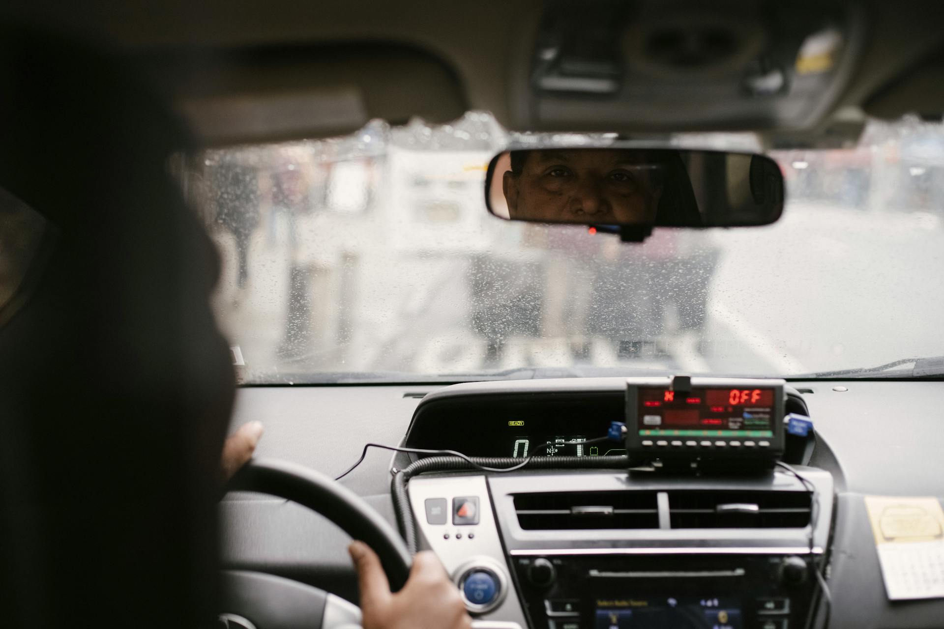 Un taxista mirando a alguien por el retrovisor | Fuente: Pexels