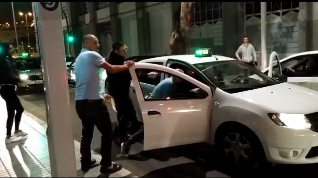 El taxista arremete contra el pasajero, mientras algunos hombres intentan detener la agresión. Fuente: Facebook / Max Gomez 