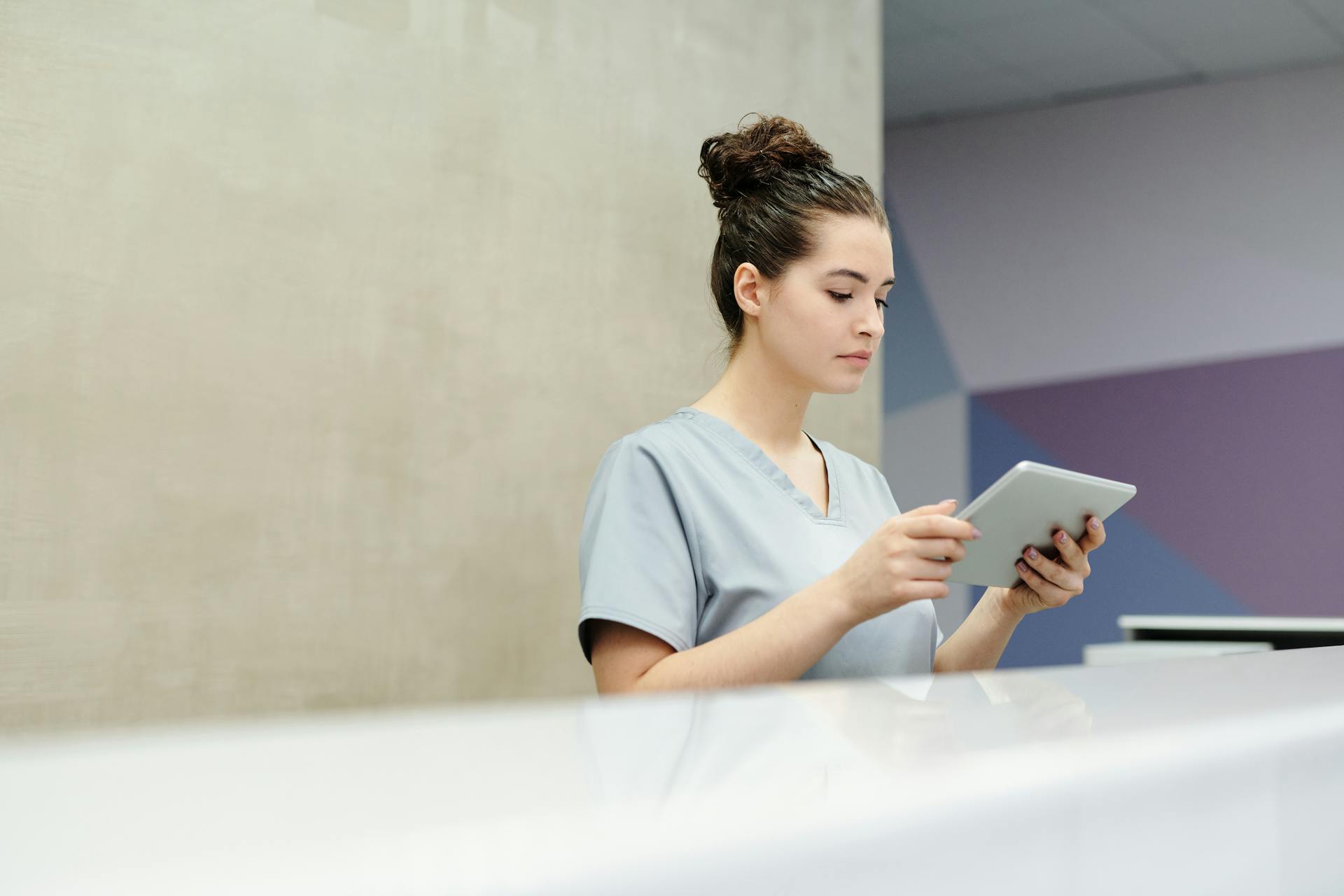 Una recepcionista sujetando una tableta | Fuente: Pexels