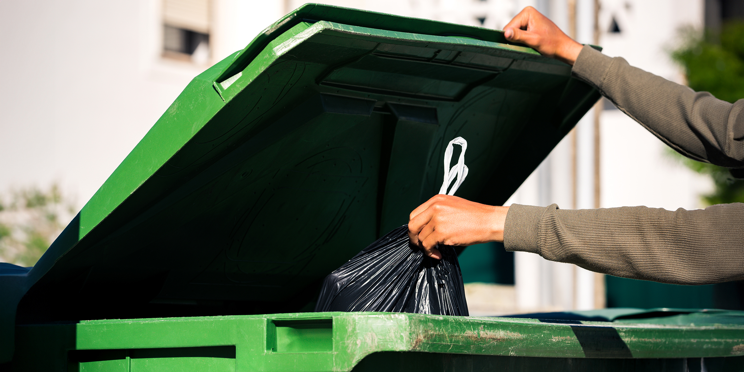 Una persona arrojando basura a un contenedor | Fuente: Shutterstock