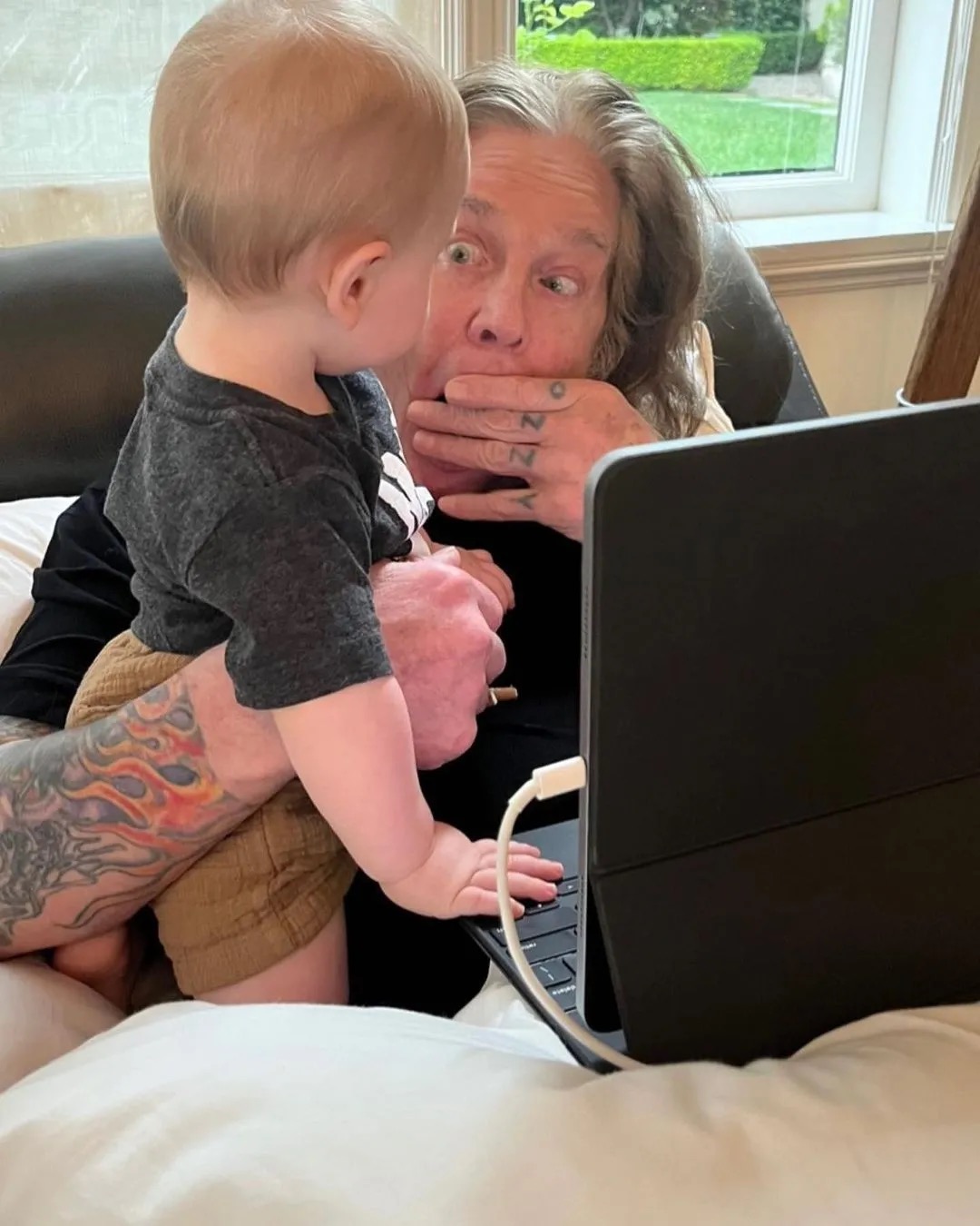 Ozzy Osbourne compartió un momento divertido con su nieto Sidney, poniendo una cara graciosa mientras el pequeño estaba de pie en su regazo. Kelly reveló más tarde que su hijo había pasado los dos primeros años de su vida viviendo con sus abuelos. | Fuente: Instagram/@sharonosbourne