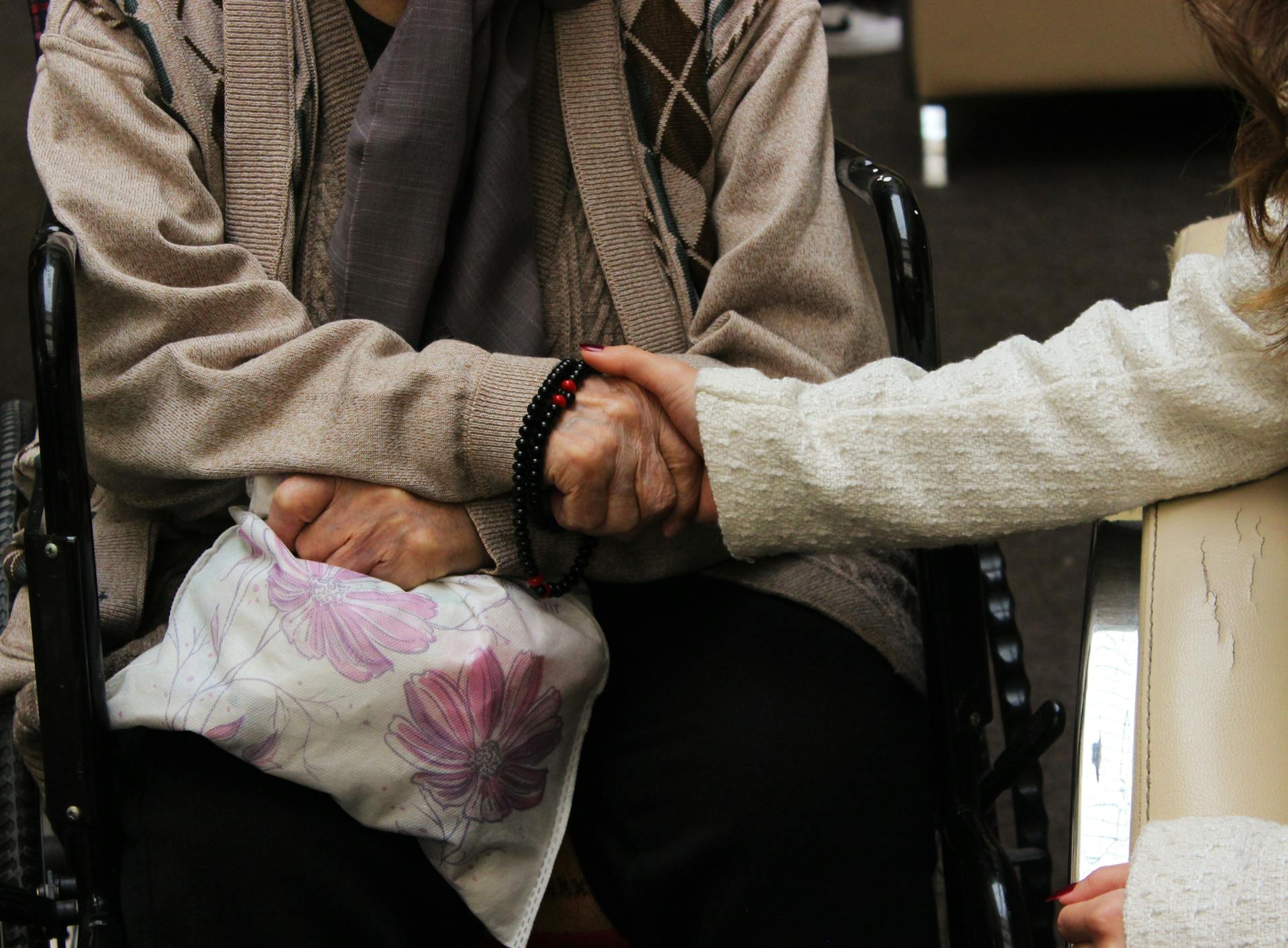 Una mujer joven tomada de la mano de una persona mayor | Fuente: Pexels
