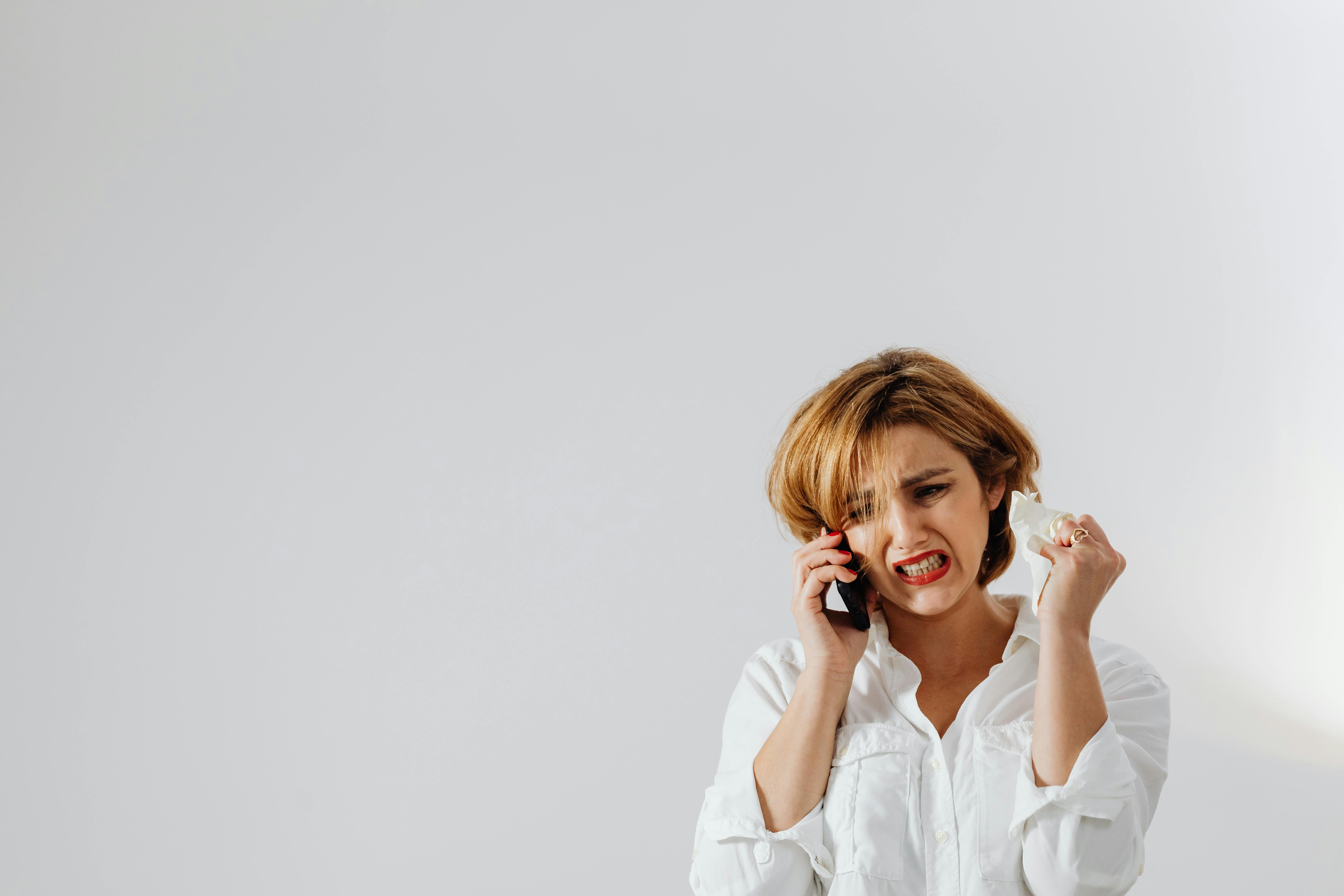 Una mujer llorando con su teléfono | Fuente: Pexels