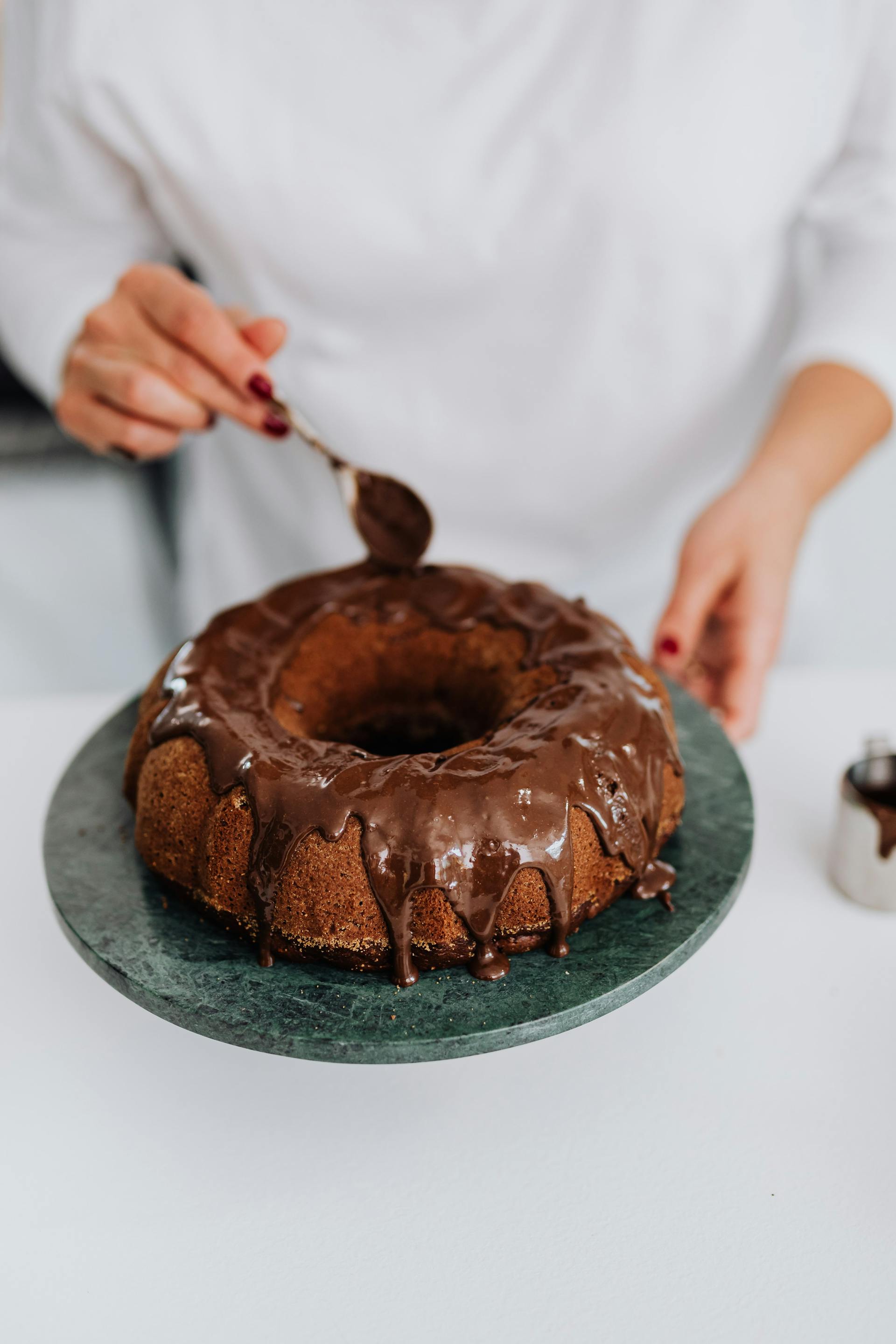 Una mujer decorando un pastel | Fuente: Pexels