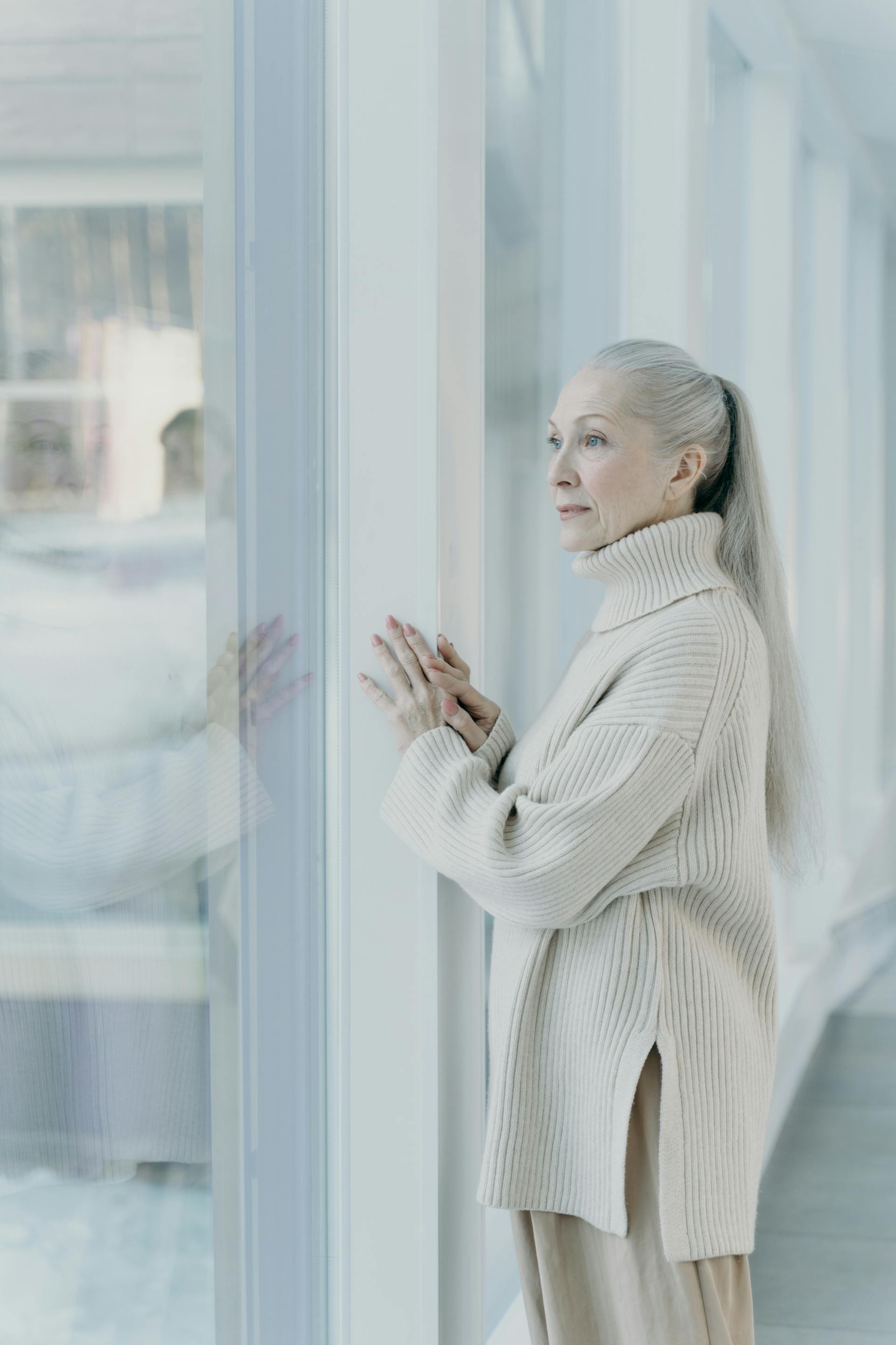 Una mujer mirando por una puerta de cristal | Fuente: Pexels